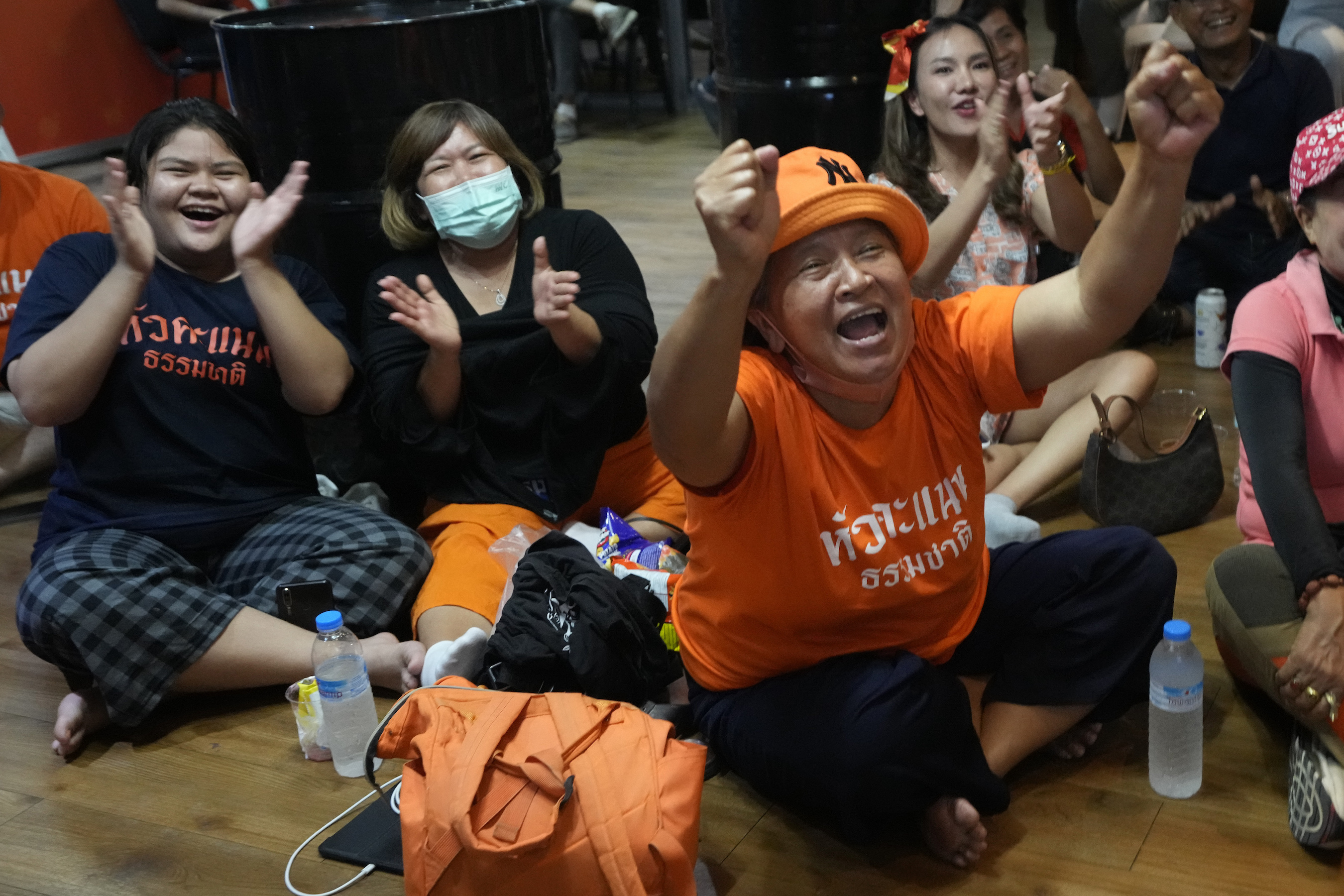 Supporters of Move Forward party cheer as they watch the counting of votes on television at Move Forward Party headquarters in Bangkok, Thailand, Sunday, May 14, 2023.