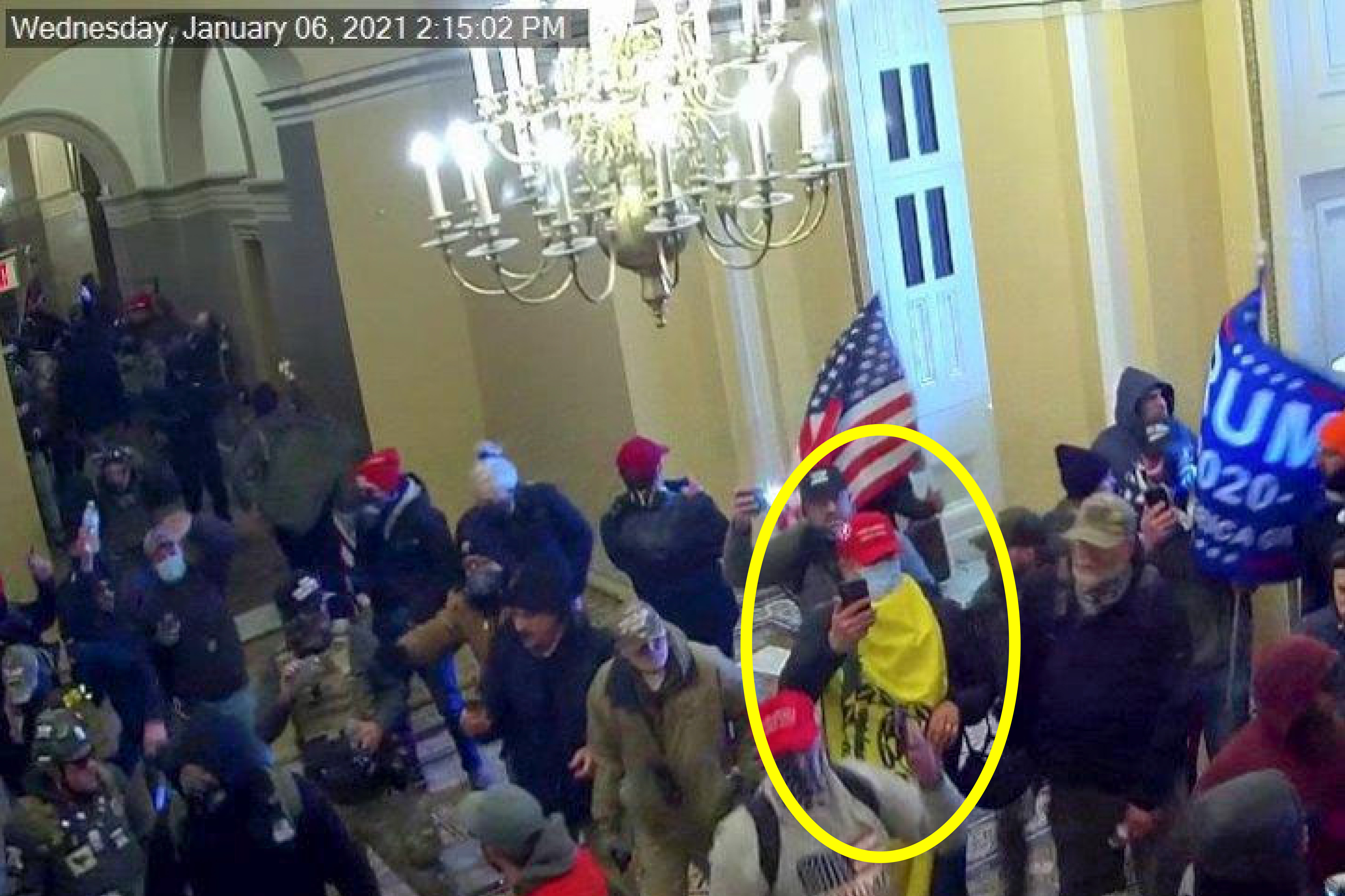 A man is circled in yellow in a video still of rioters rushing into the US Capitol