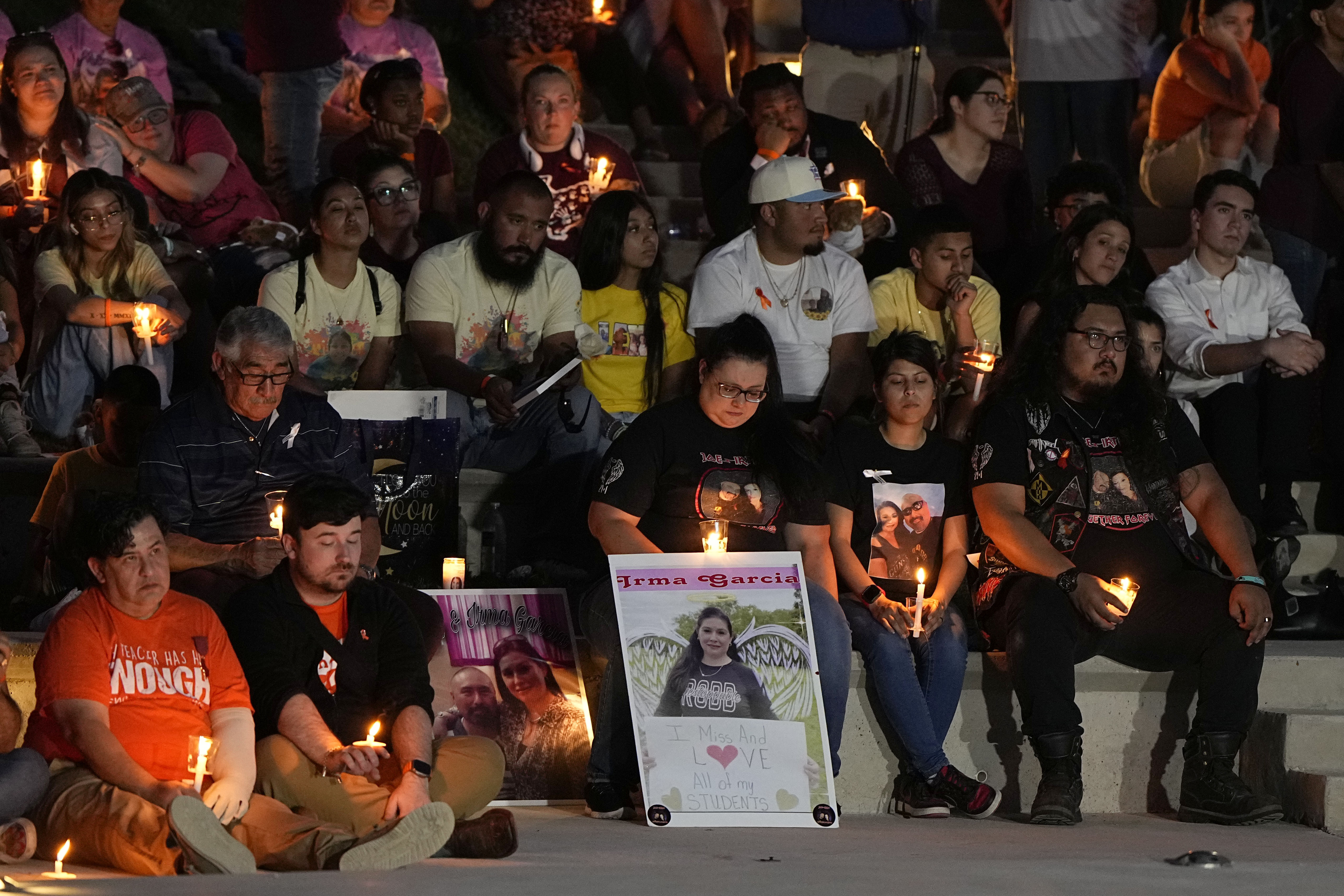 Rows of people holding candles join for a memorial of the lives lost at a Uvalde elementary school.