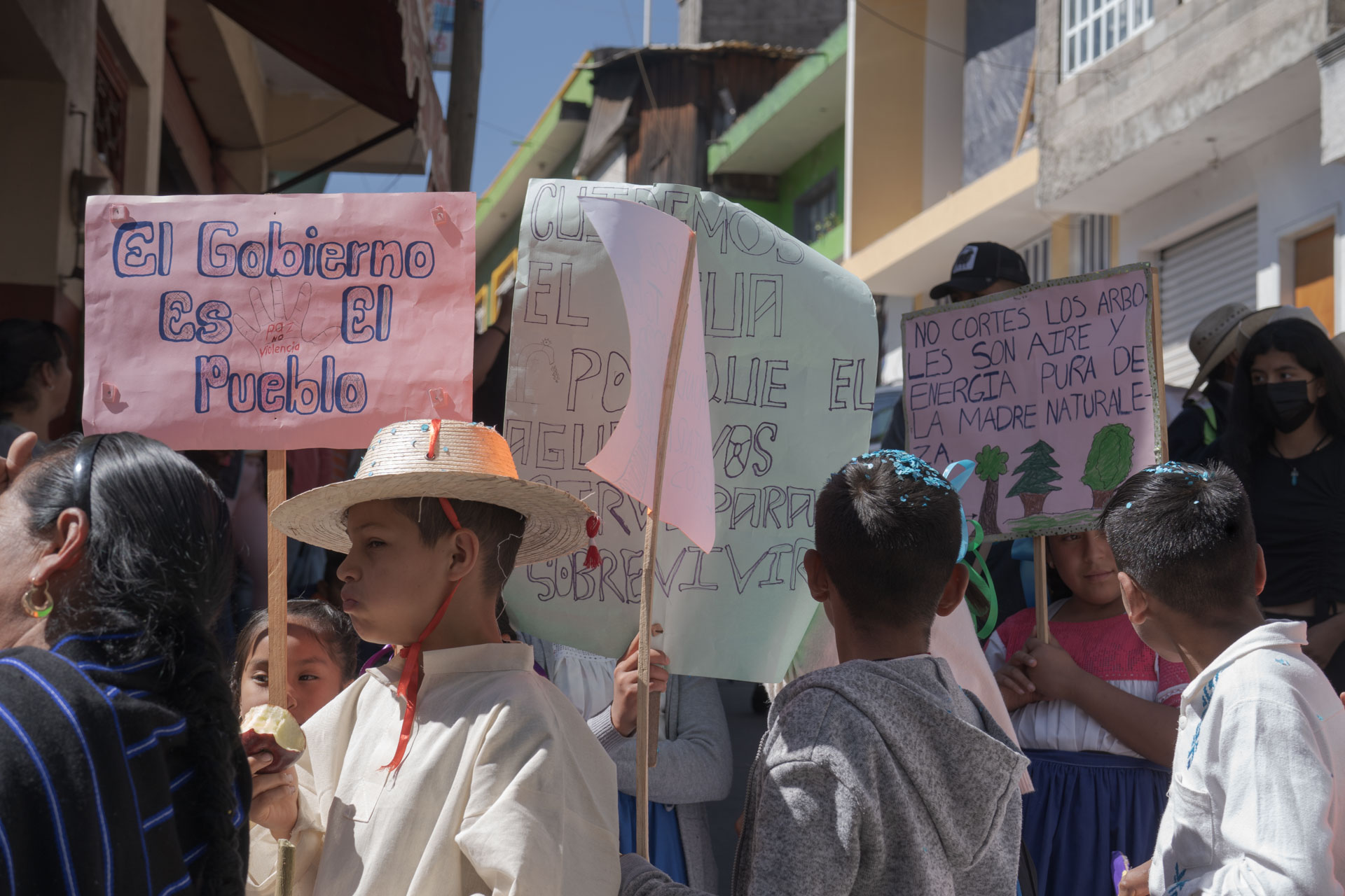 People carry handwritten signs with environmental messages at an outdoor protest