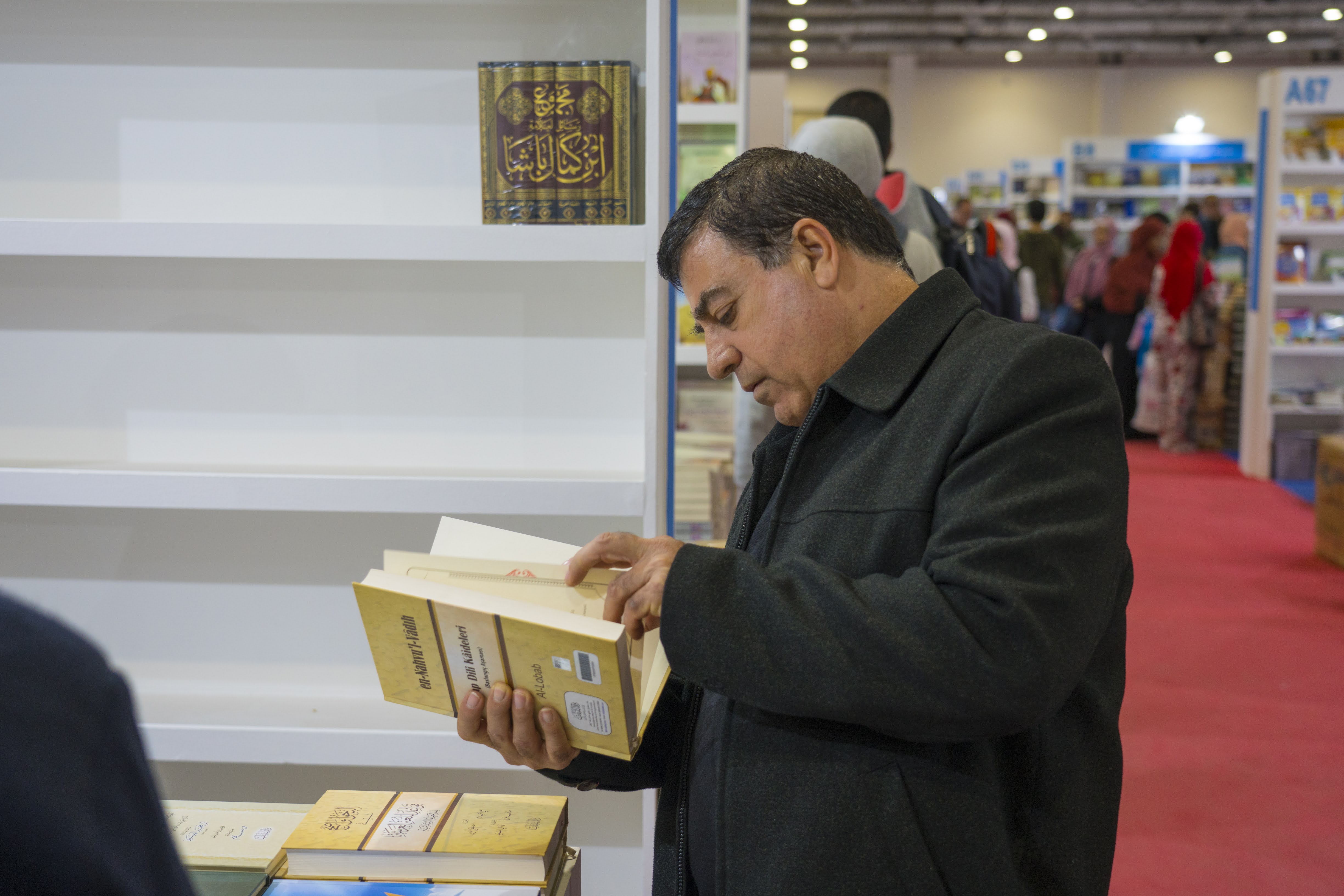 Michel reading a book at a book fair