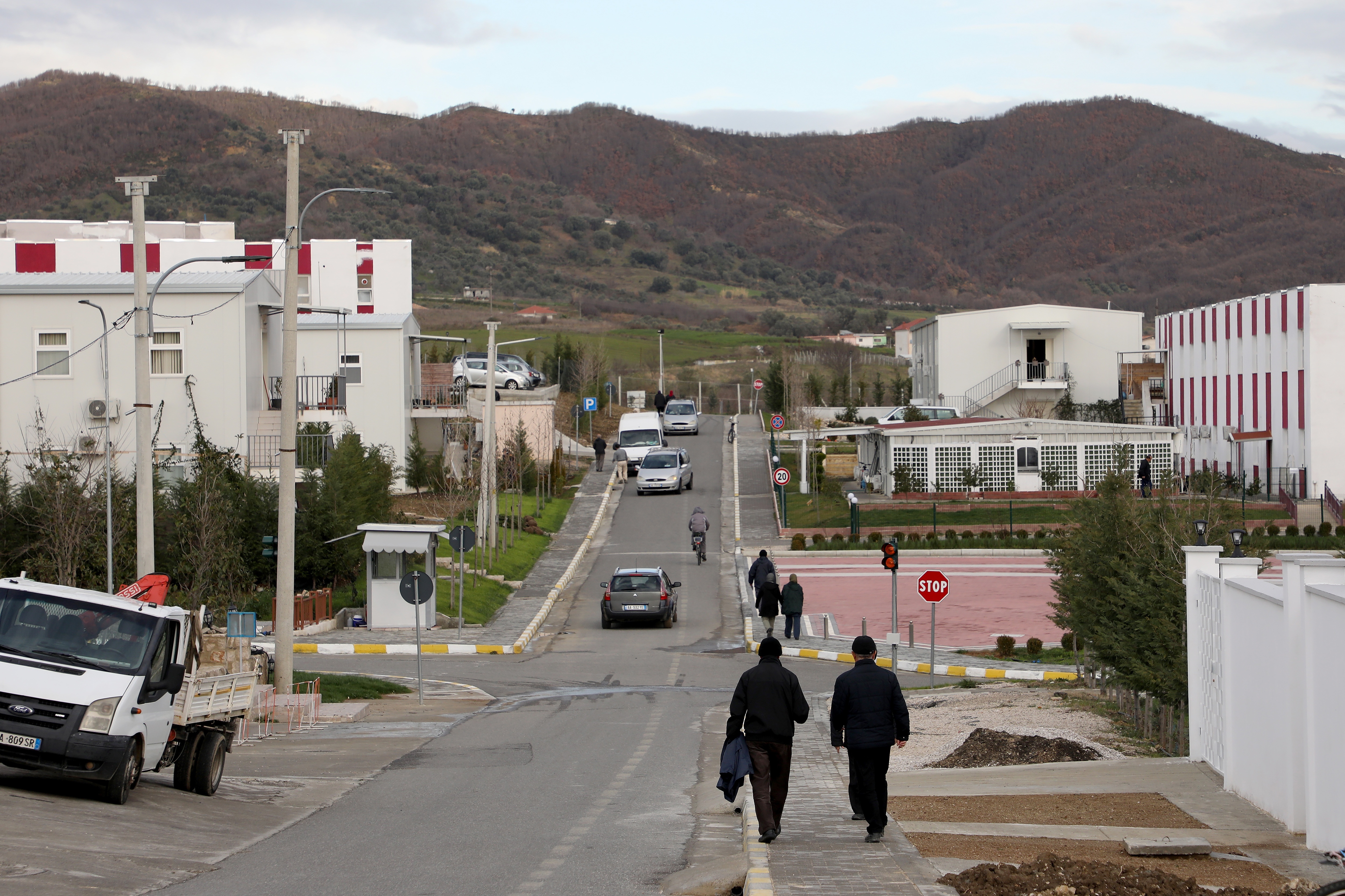 A street at Ashraf-3 camp with hills in the background
