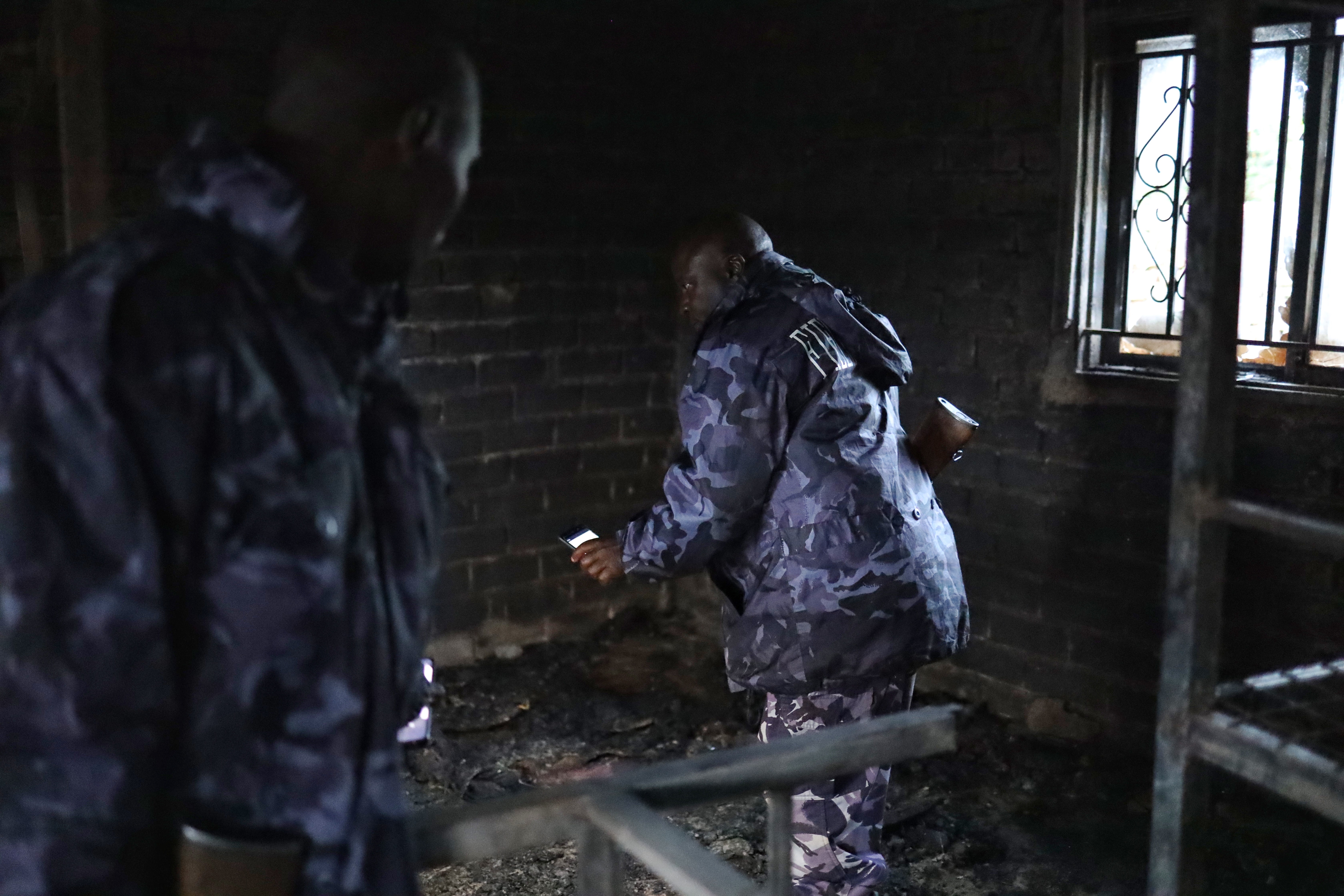 Uganda security forces are seen at the premises of an attack