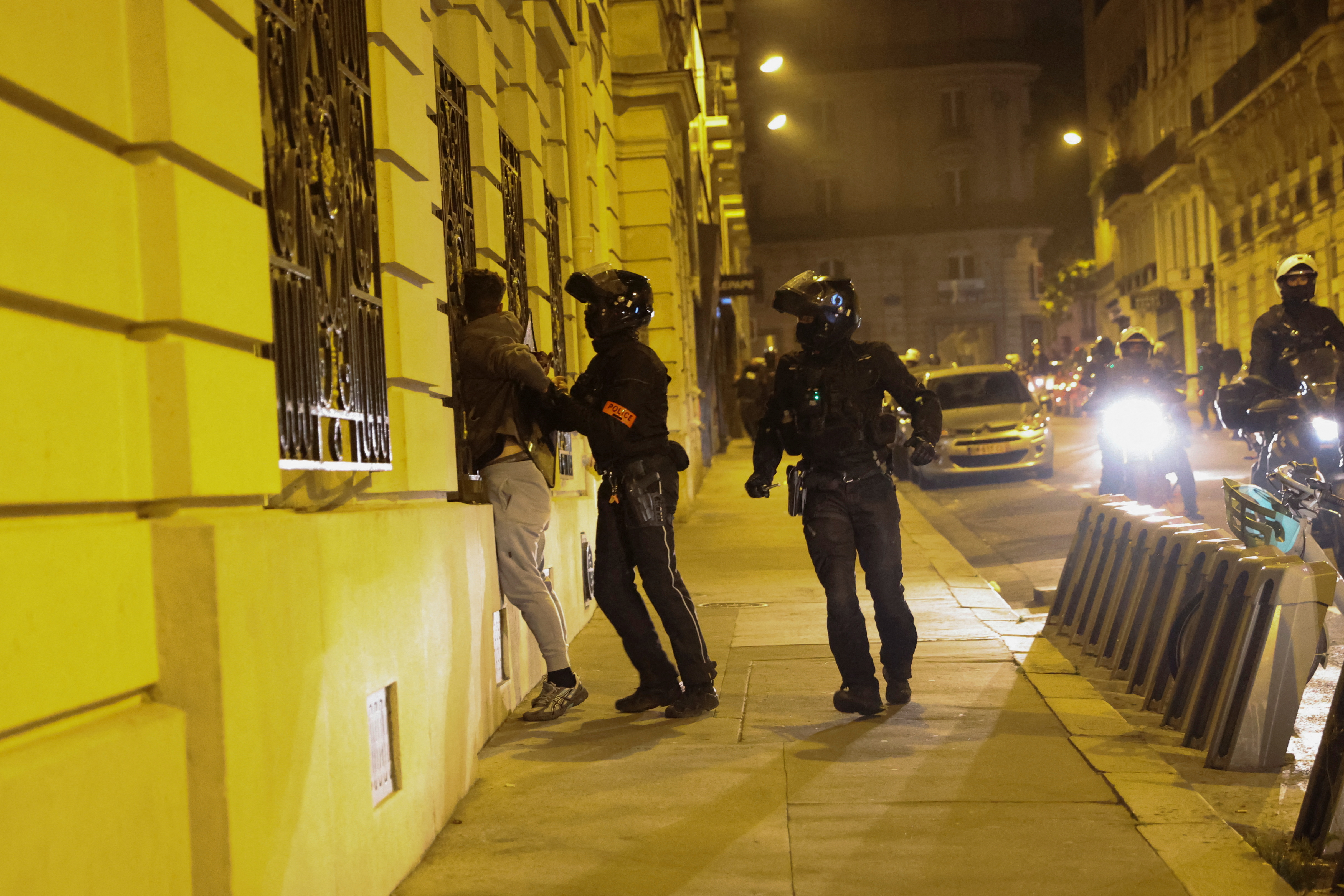 Police officers detain a person during protests following the death of Nahel, a 17-year-old teenager killed by a French police officer in Nanterre during a traffic stop