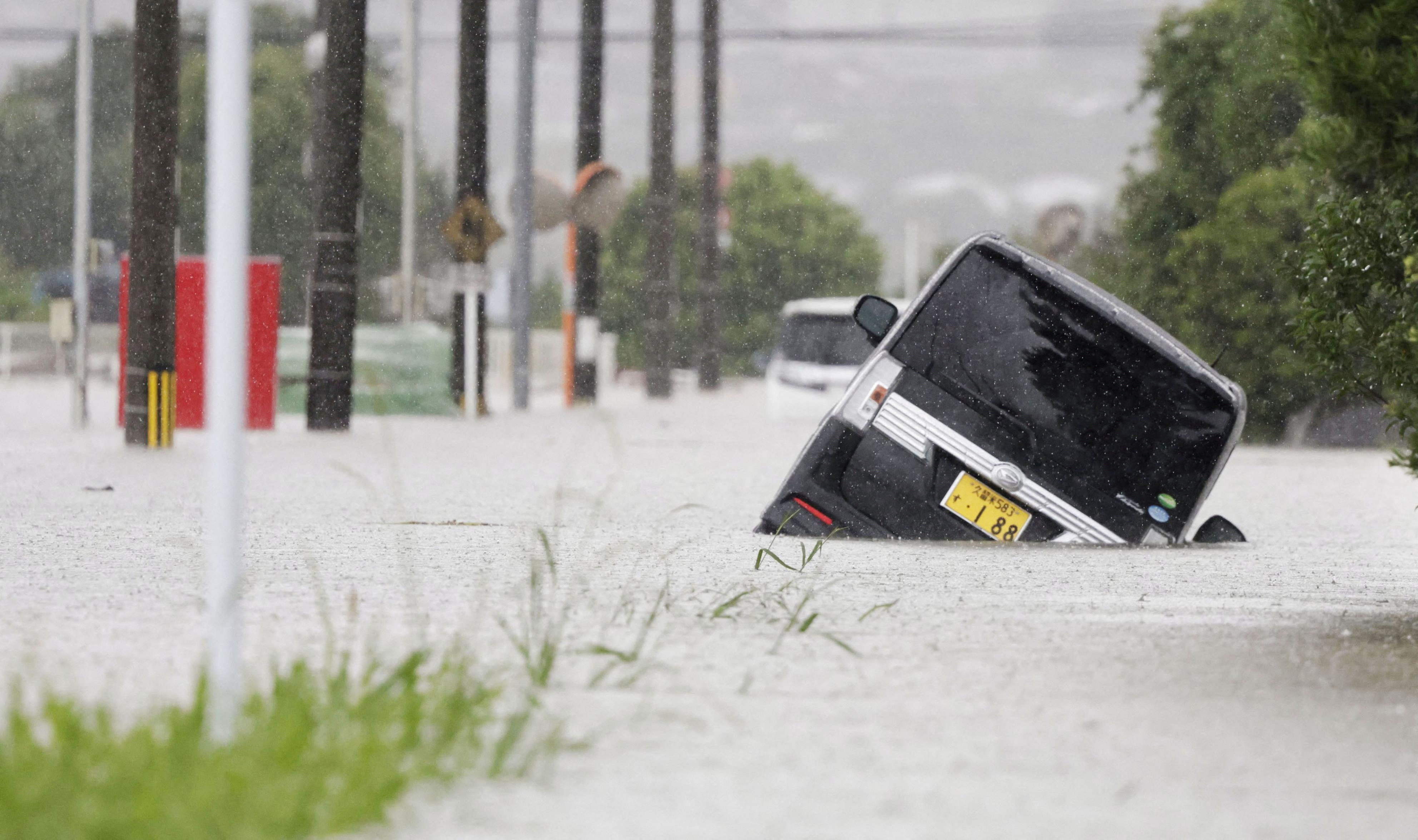 Cars are stranded in a flooded road in heavy rain in Kurume, Fukuoka Prefecture