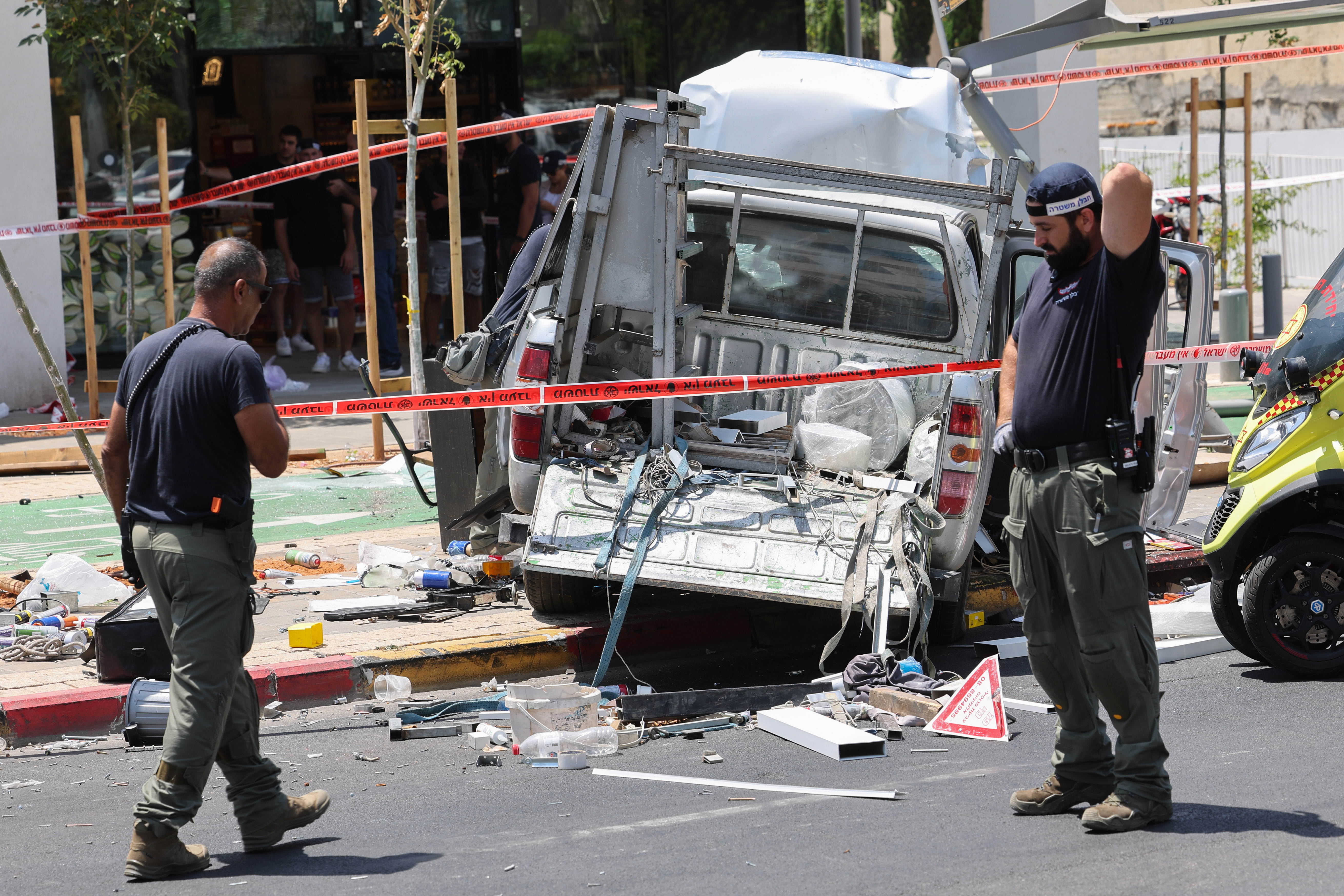 Members of Israeli security and emergency personnel work at the site of a reported car ramming attack in Tel Aviv