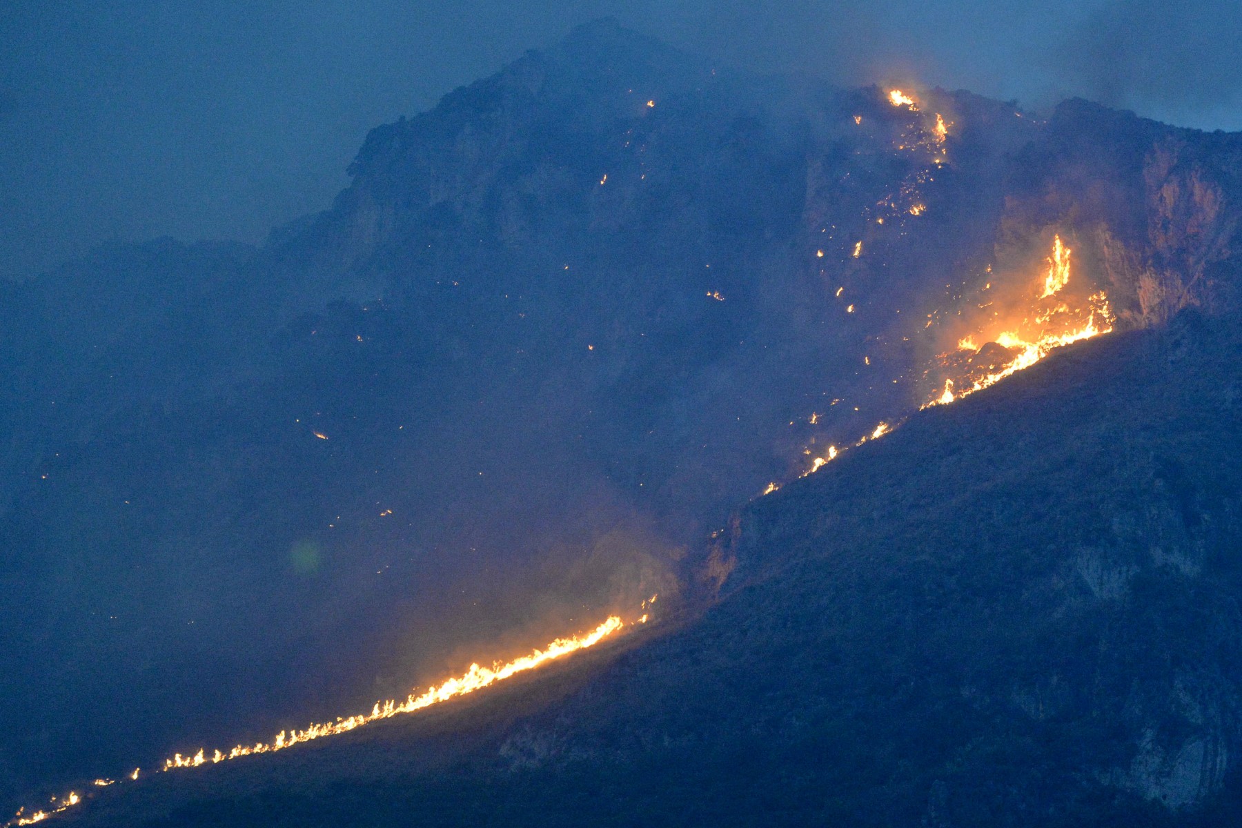 This photo obtained from Italian news agency Ansa shows a vast fire spreading on hills in the area of Monte Grifone and the town of Ciaculli around Palermo, Sicily