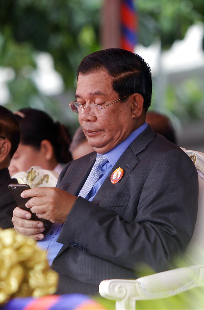Cambodia's Prime Minister Hun Sen views his smart phone during the celebrations of the 65th anniversary of the ruling Cambodian People 's Party in Phnom Penh, Cambodia, Tuesday, June 28, 2016. Several hundreds of supporters participated in the celebrations. (AP Photo/Heng Sinith)