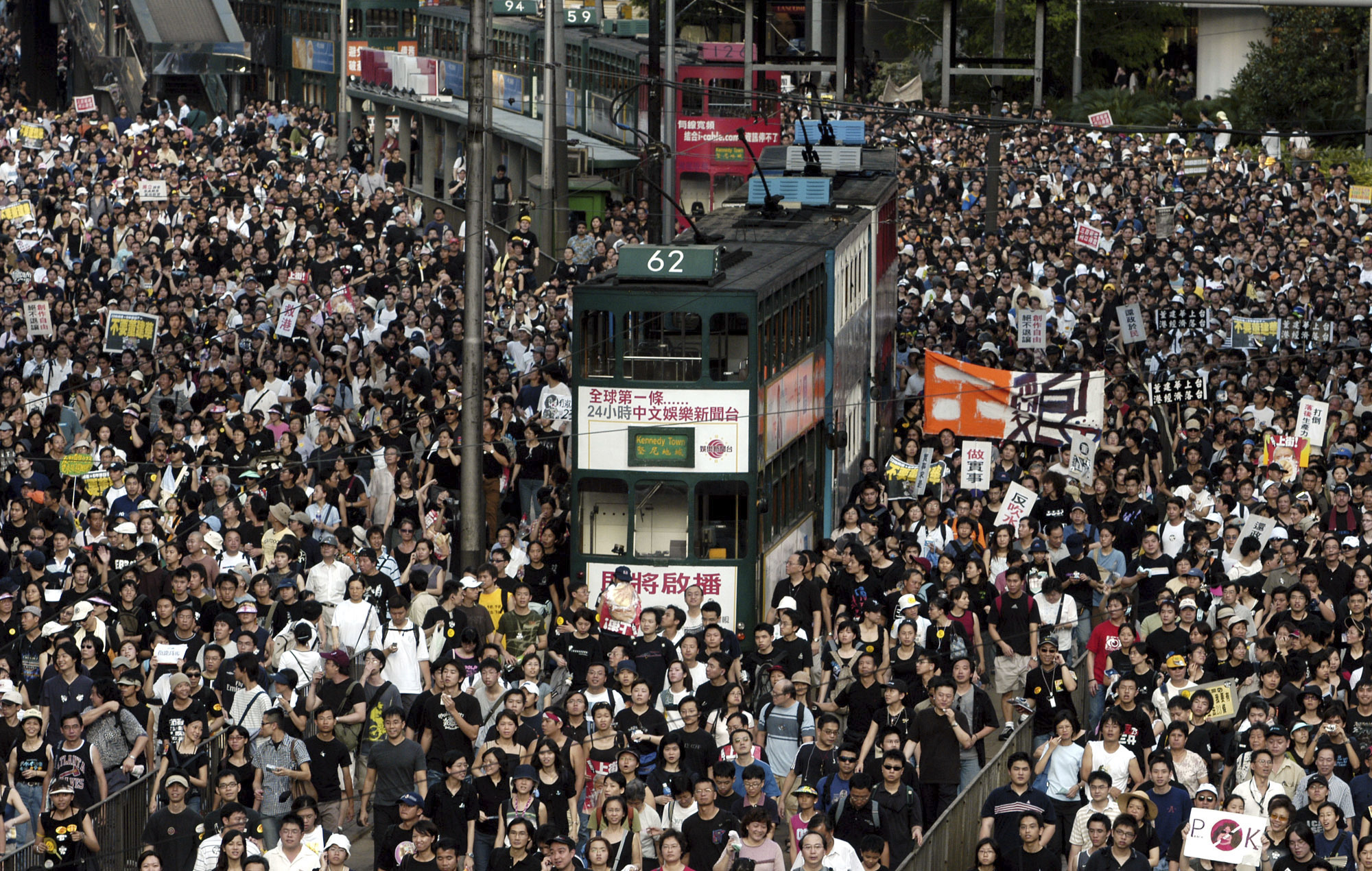 A mass protest in Hong Kong in 2003 over a planned security bill. There is a double decker bus in the middle of the crowd