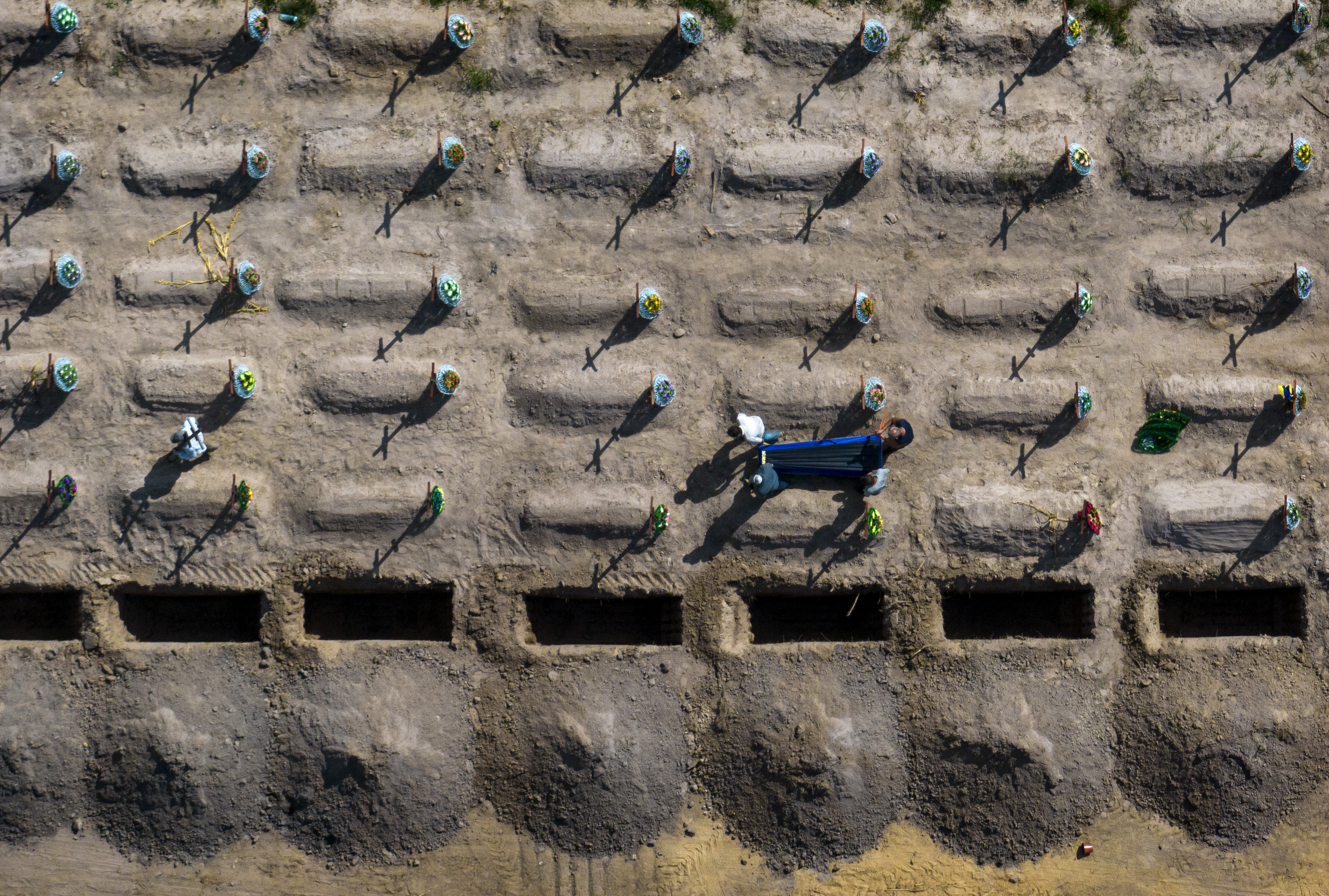 Funeral workers carry a coffin with an unidentified civilian body,