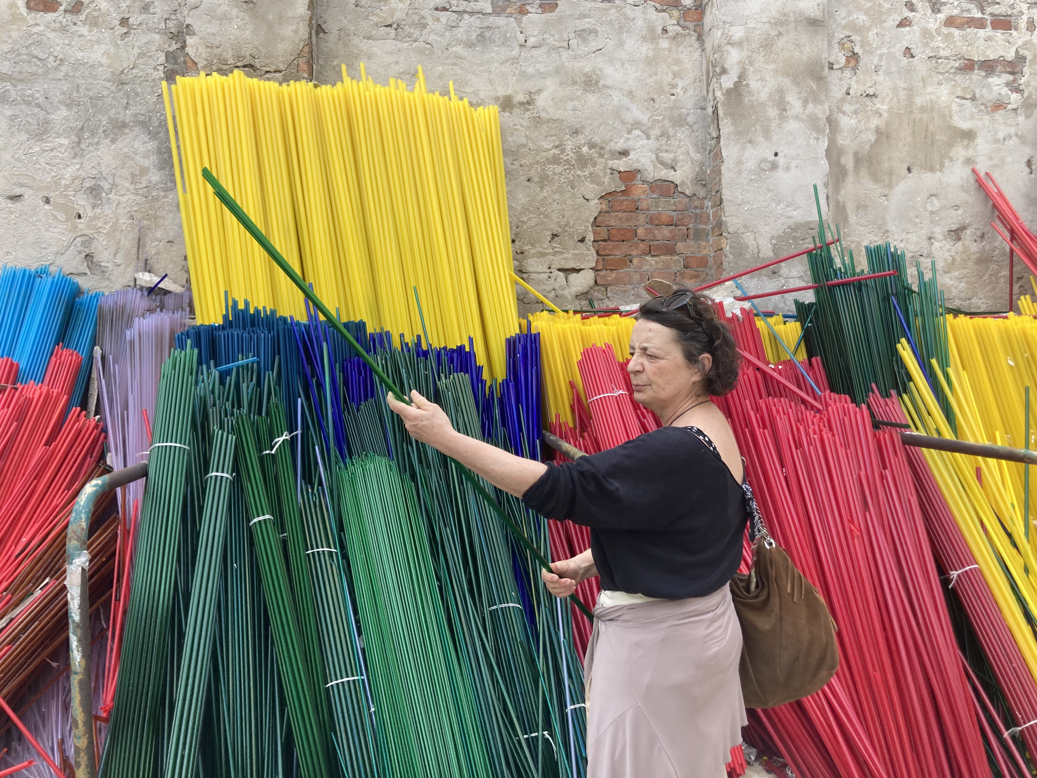 A glassblower examines some glass rods