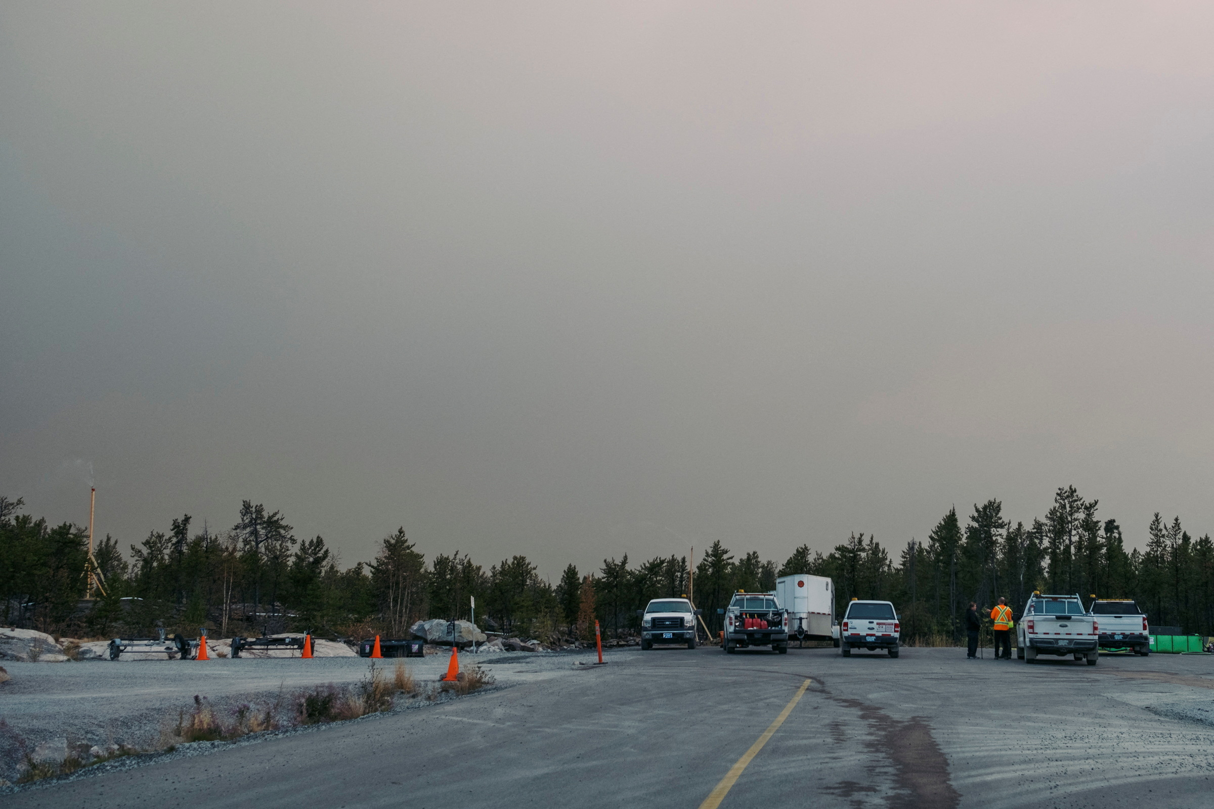 City of Yellowknife workers and firefighters monitor sprinkler systems in a neighbourhood at the city's edge, after a state of emergency was declared, in Yellowknife