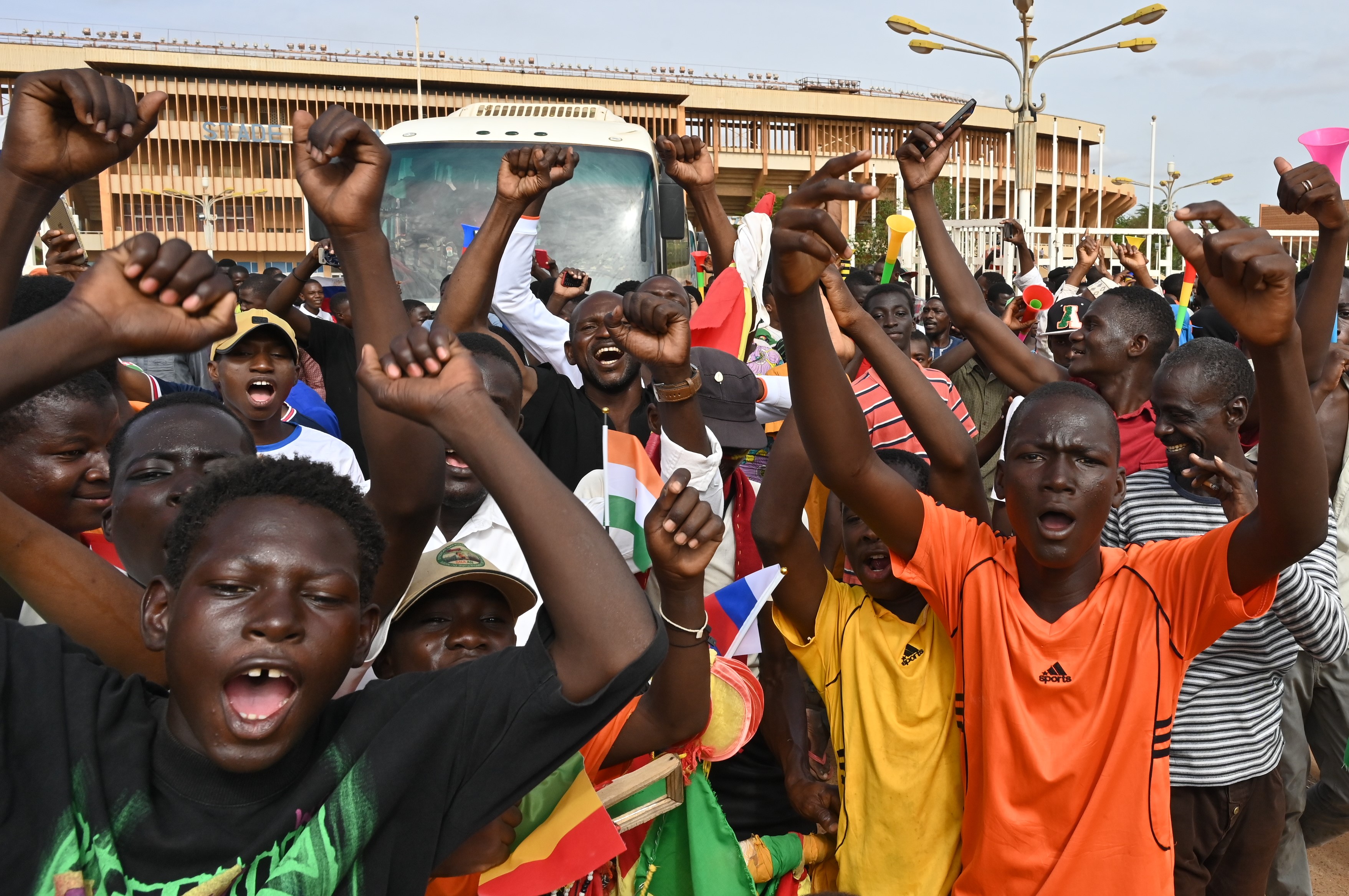 Supporters of Niger's National Council for the Safeguard of the Homeland (CNSP) demonstrate in Niamey on August 6, 2023. - Thousands of supporters of the military coup in Niger gathered at a Niamey stadium Sunday, when a deadline set by the West African regional bloc ECOWAS to return the deposed President Mohamed Bazoum to power is set to expire, according to AFP journalists. A delegation of members of the ruling National Council for the Safeguard of the Homeland (CNSP) arrived at the 30,000-seat stadium to cheers from supporters, many of whom were drapped in Russian flags and portraits of CNSP leaders. (Photo by - / AFP)