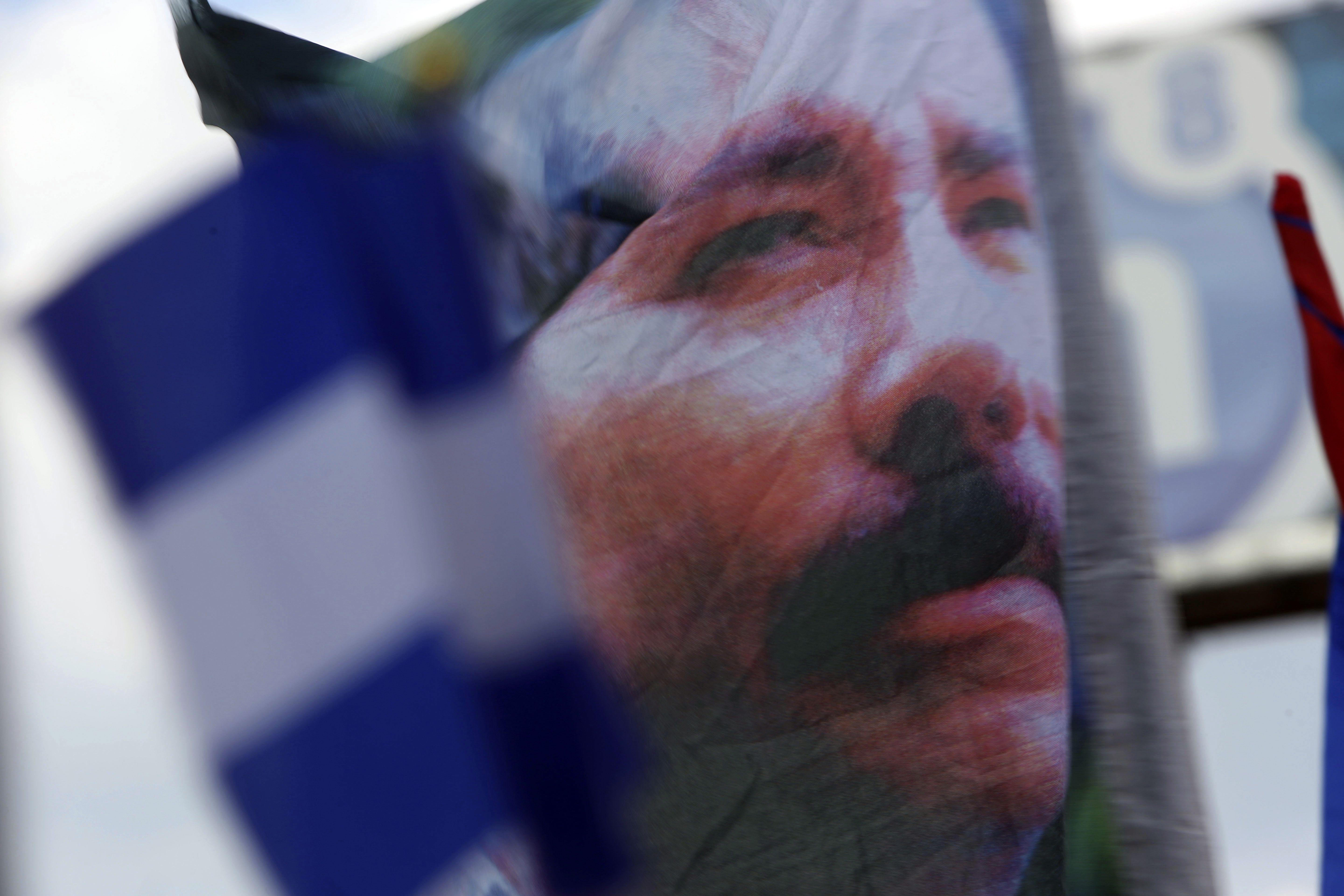 A banner emblazoned with an image of Nicaragua's President Daniel Ortega is waved by a supporter in Managua, Nicaragua, April 30, 2018. Ortega has forced hundreds of opposition figures into exile, stripping them of their citizenship, seizing their properties and declaring them “traitors of the homeland.”
