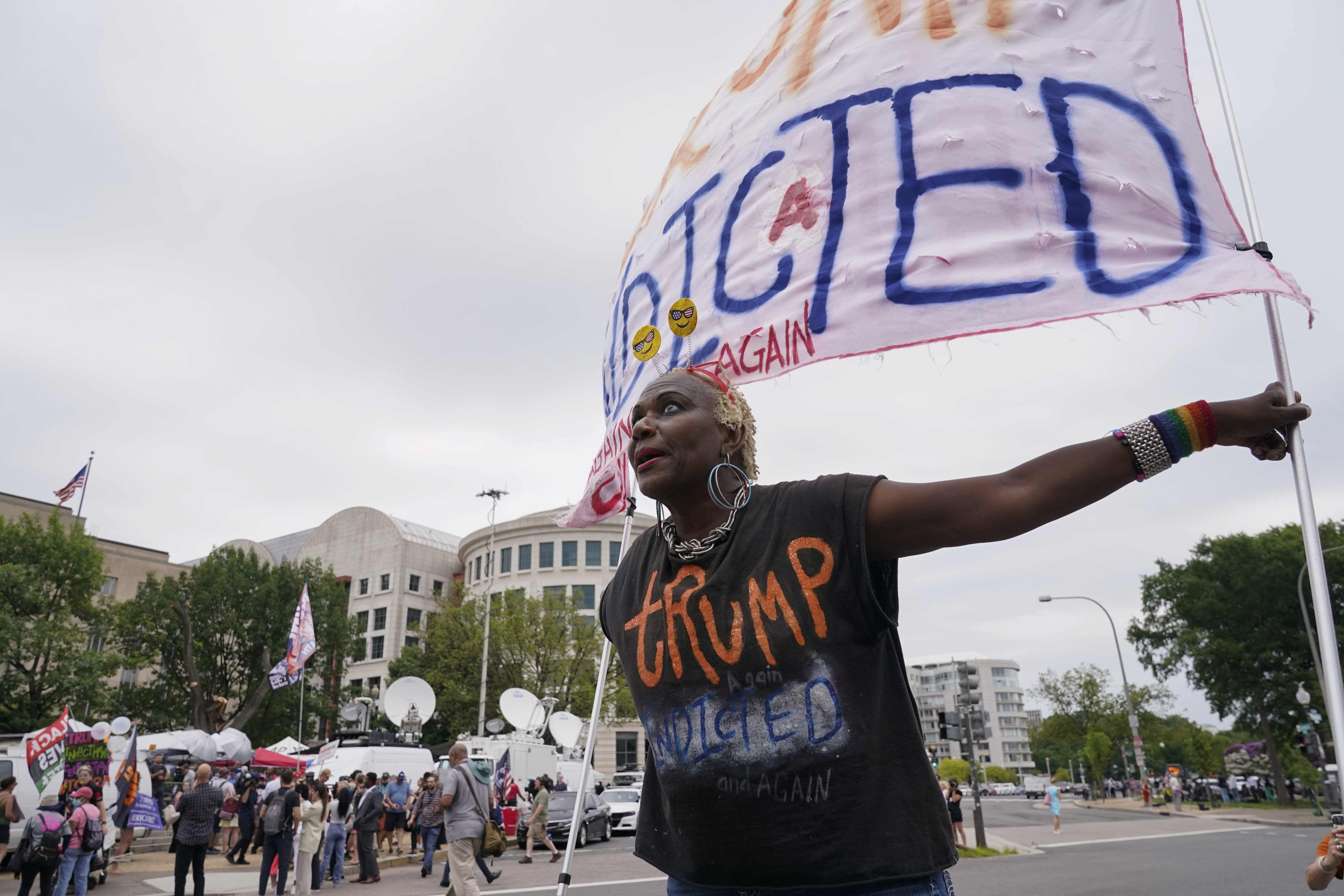 Nadine Seiler holds a banner near the E. Barrett Prettyman U.S. Federal Courthouse,