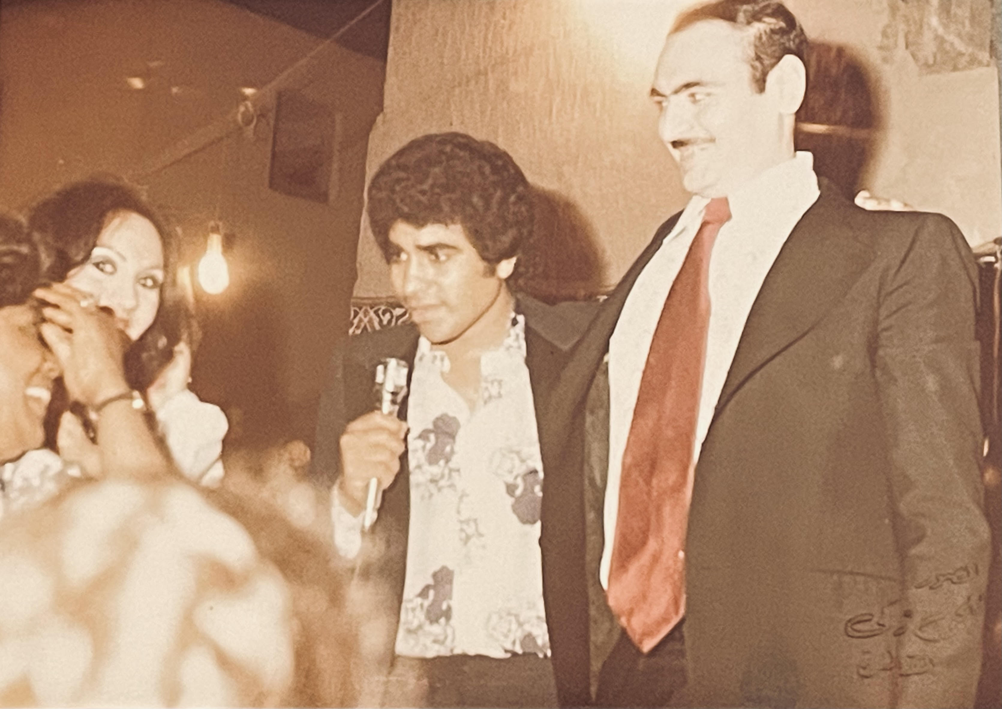 A photo of a printed photo showing young Adawiya with a mic, talking to the audience