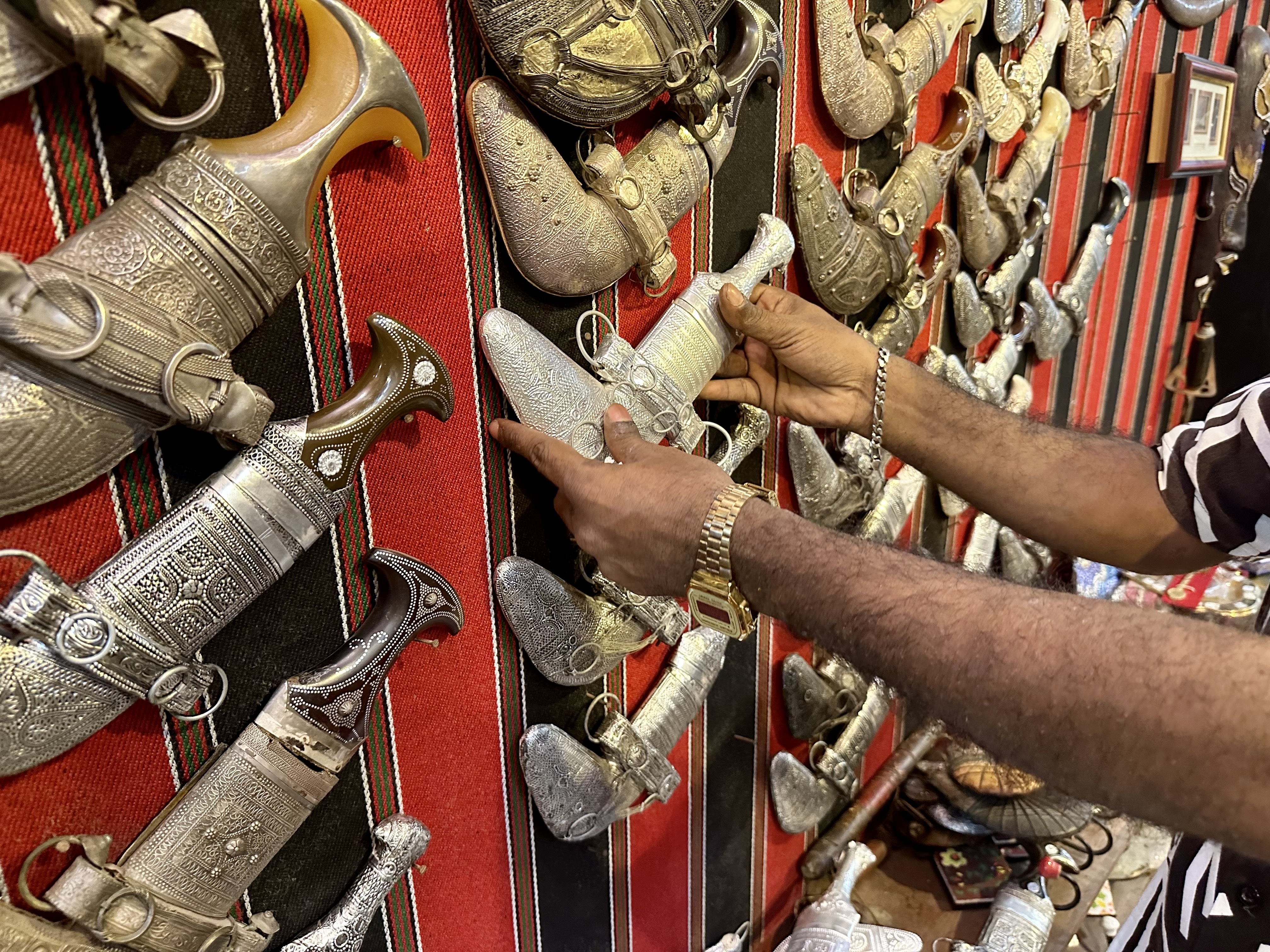Razzaq shows the khanjar, a traditional Omani dagger, on display at the shop he works in