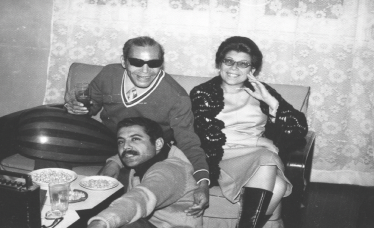 Sheikh Imam smiles with hand on his friend's back