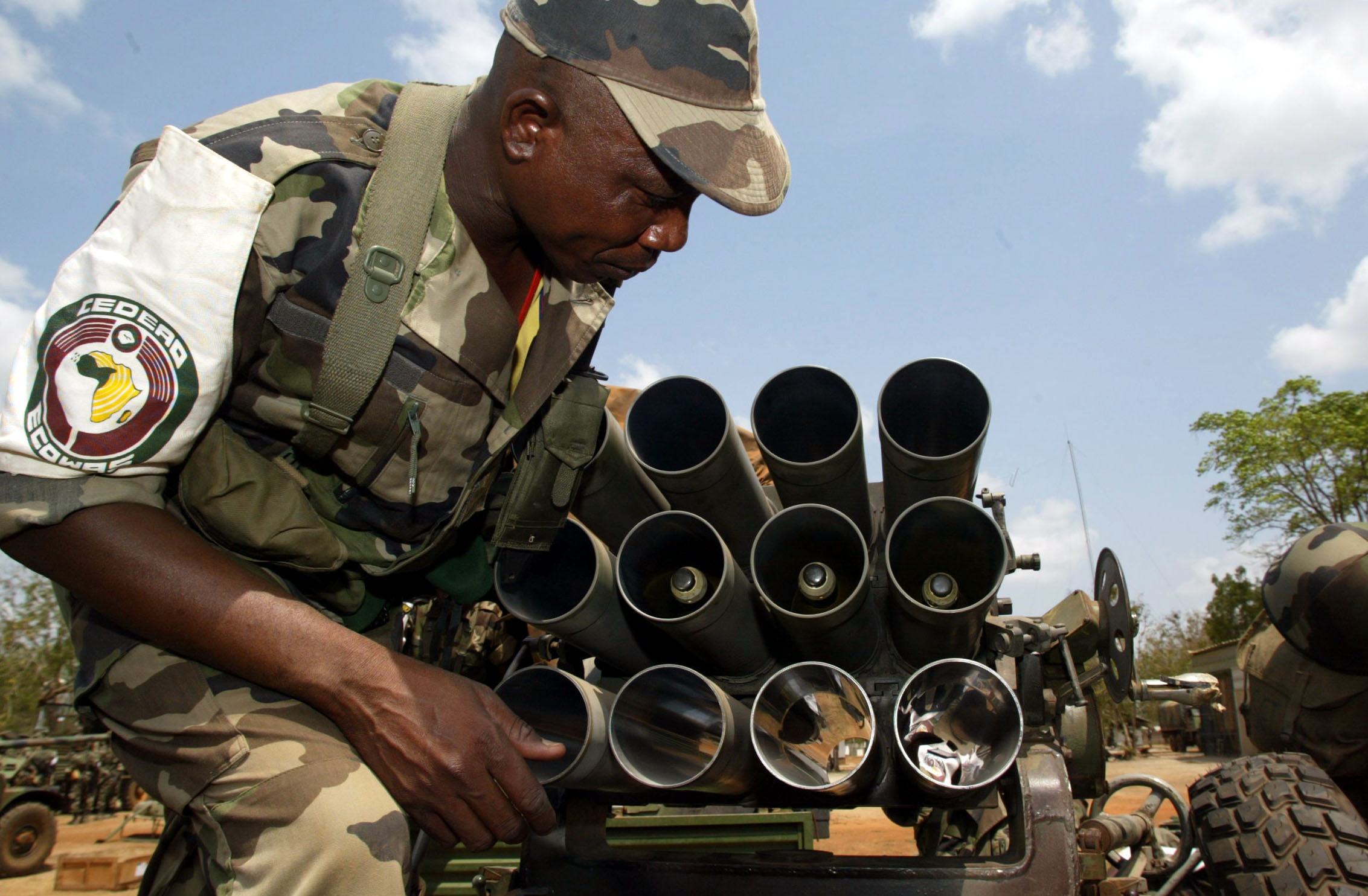 An ECOMOG soldier from Niger, the military arm of the Economic Community of West African States, adjusts a rocket launcher in the village of Lomo nord, in central Ivory Coast 14 February 2003