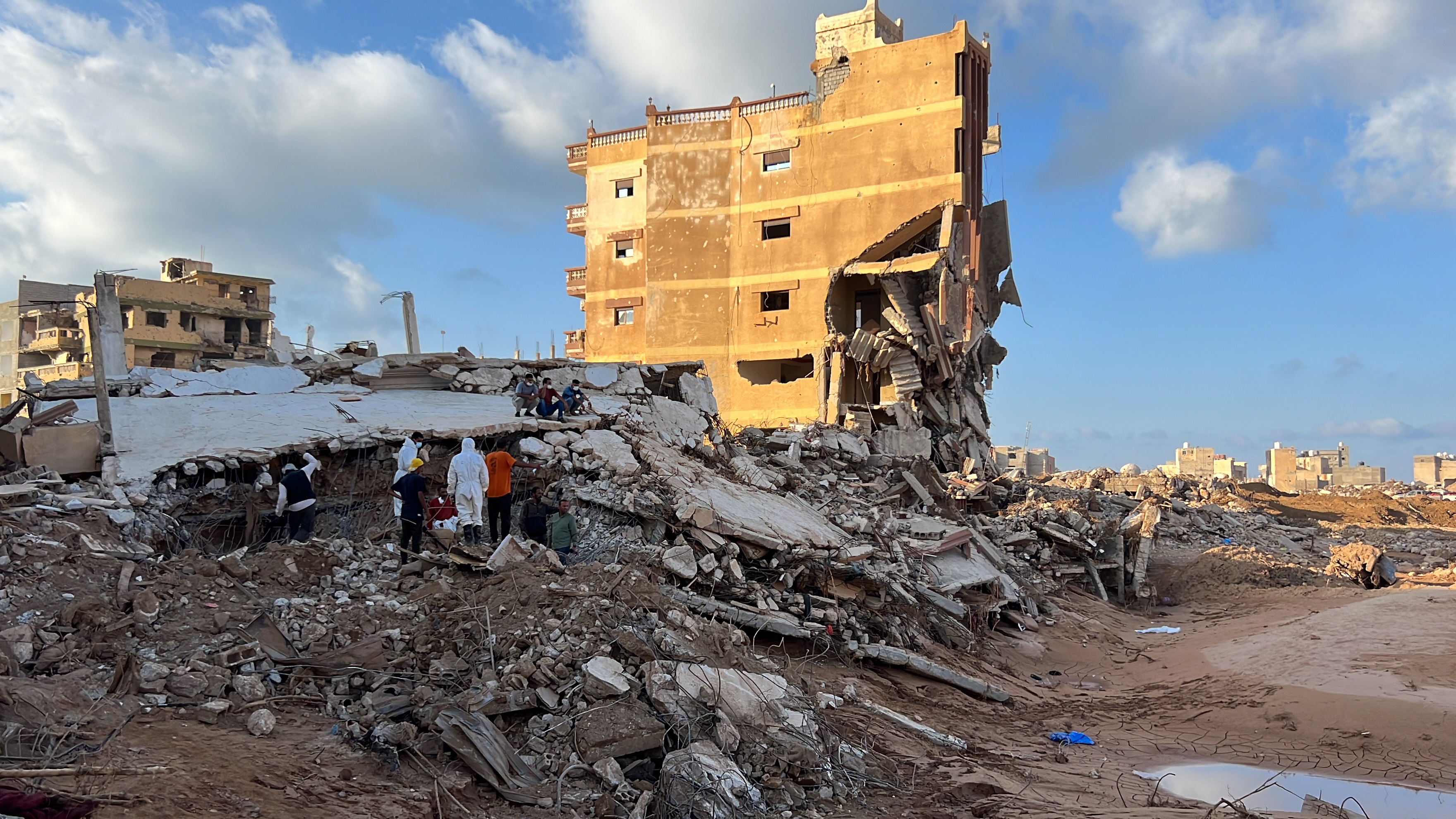 Rescuers search for possible survivors and bodies of victims under a collapsed building after Storm Daniel swept across eastern Libya, in the port city of Derna