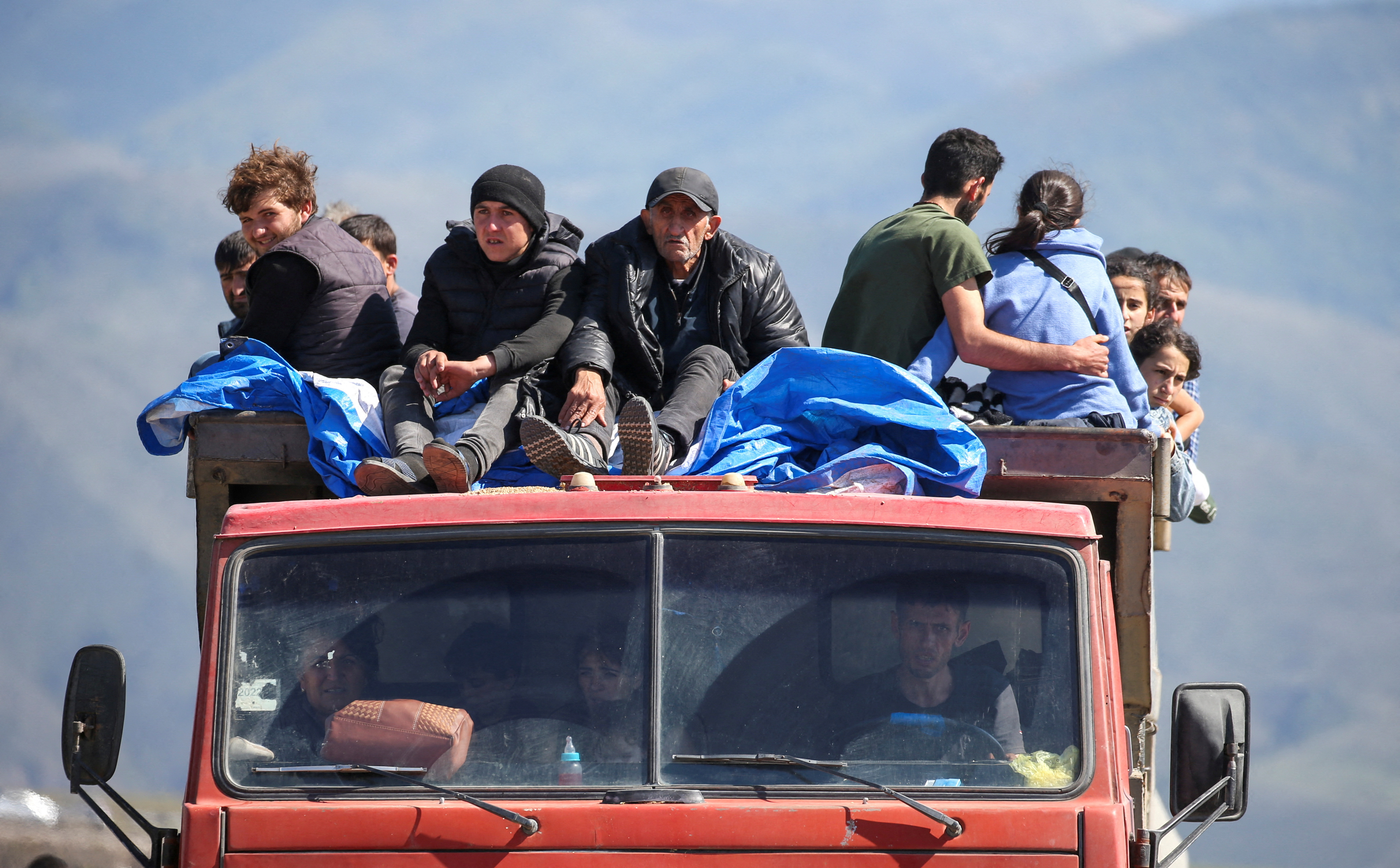 Refugees from Nagorno-Karabakh region ride in a truck upon their arrival at the border village of Kornidzor, Armenia, September 27, 2023