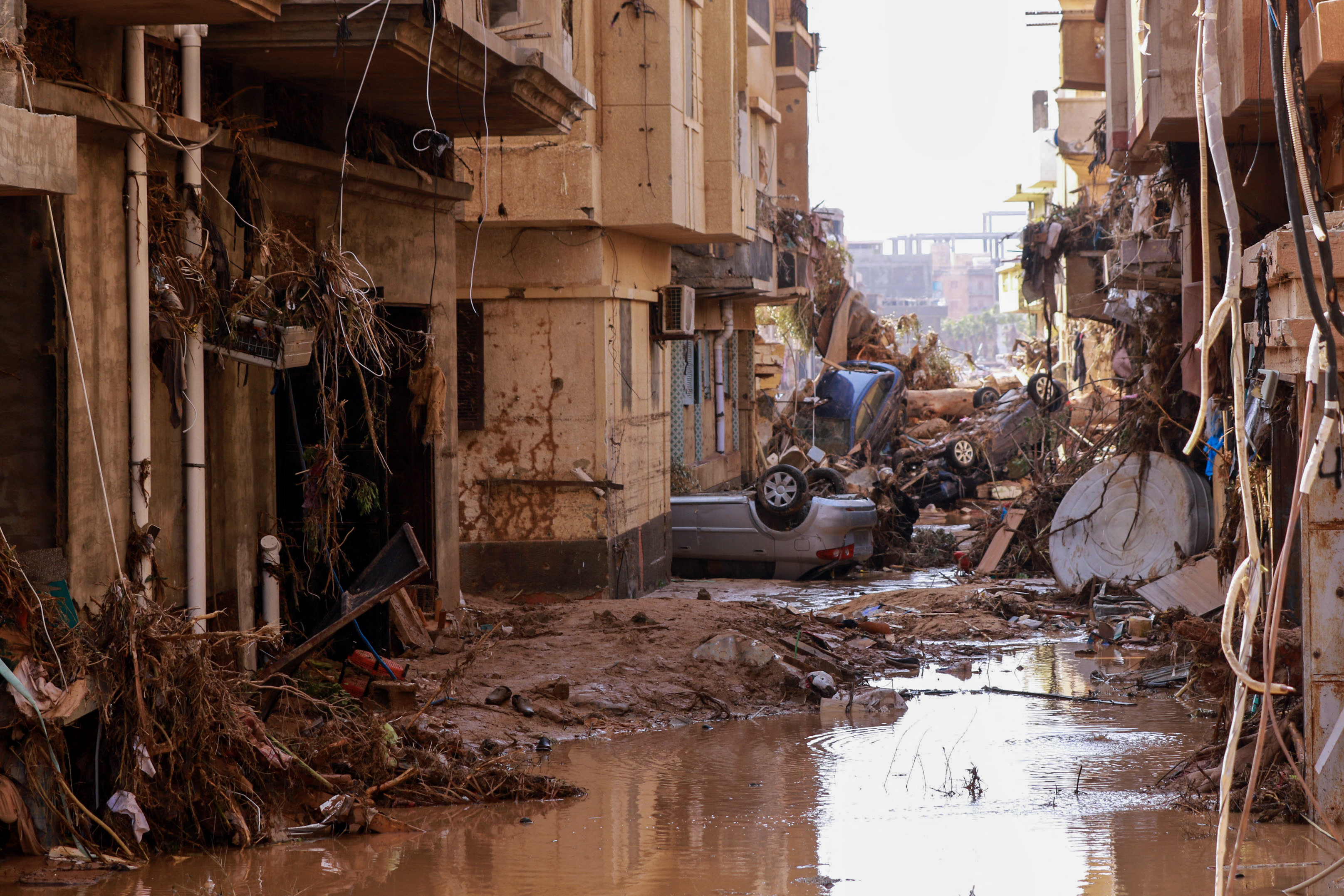 Overturned cars lay among other debris caused by flash floods in Derna, eastern Libya, on September 11, 2023. - Flash floods in eastern Libya killed more than 2,300 people in the Mediterranean coastal city of Derna alone, the emergency services of the Tripoli-based government said on September 12. (Photo by AFP)