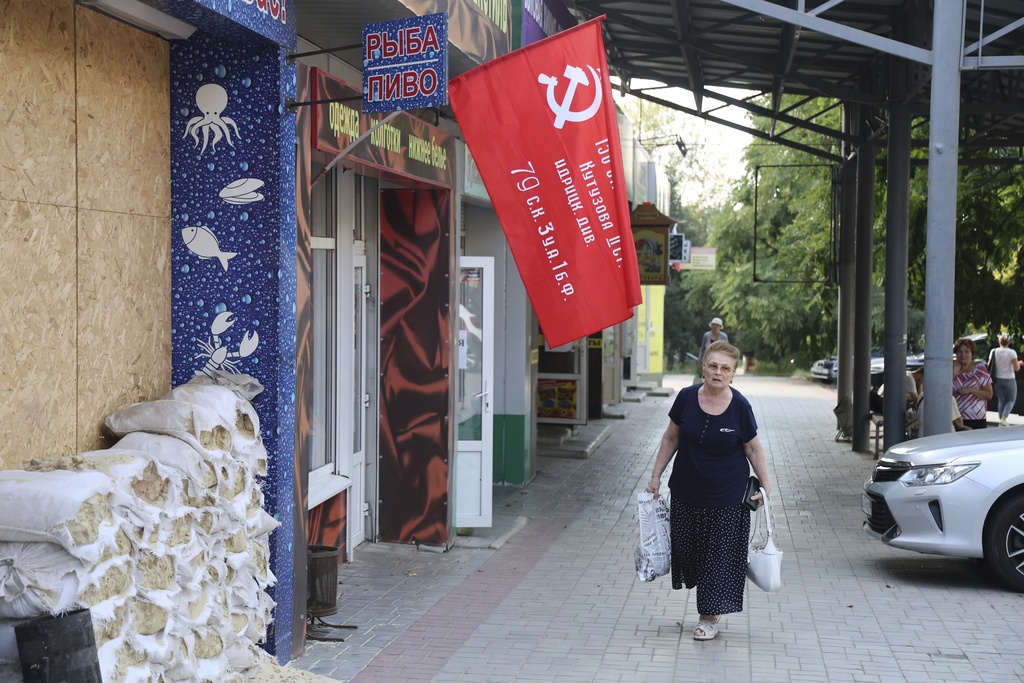 A woman walks past a shop in Donetsk