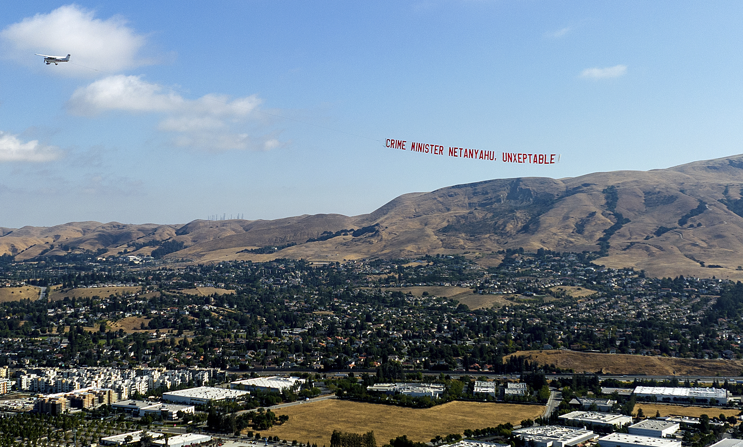 A plane flies a banner protesting against Israeli Prime Minister Benjamin Netanyahu as he visits Tesla's Fremont, Calif., factory