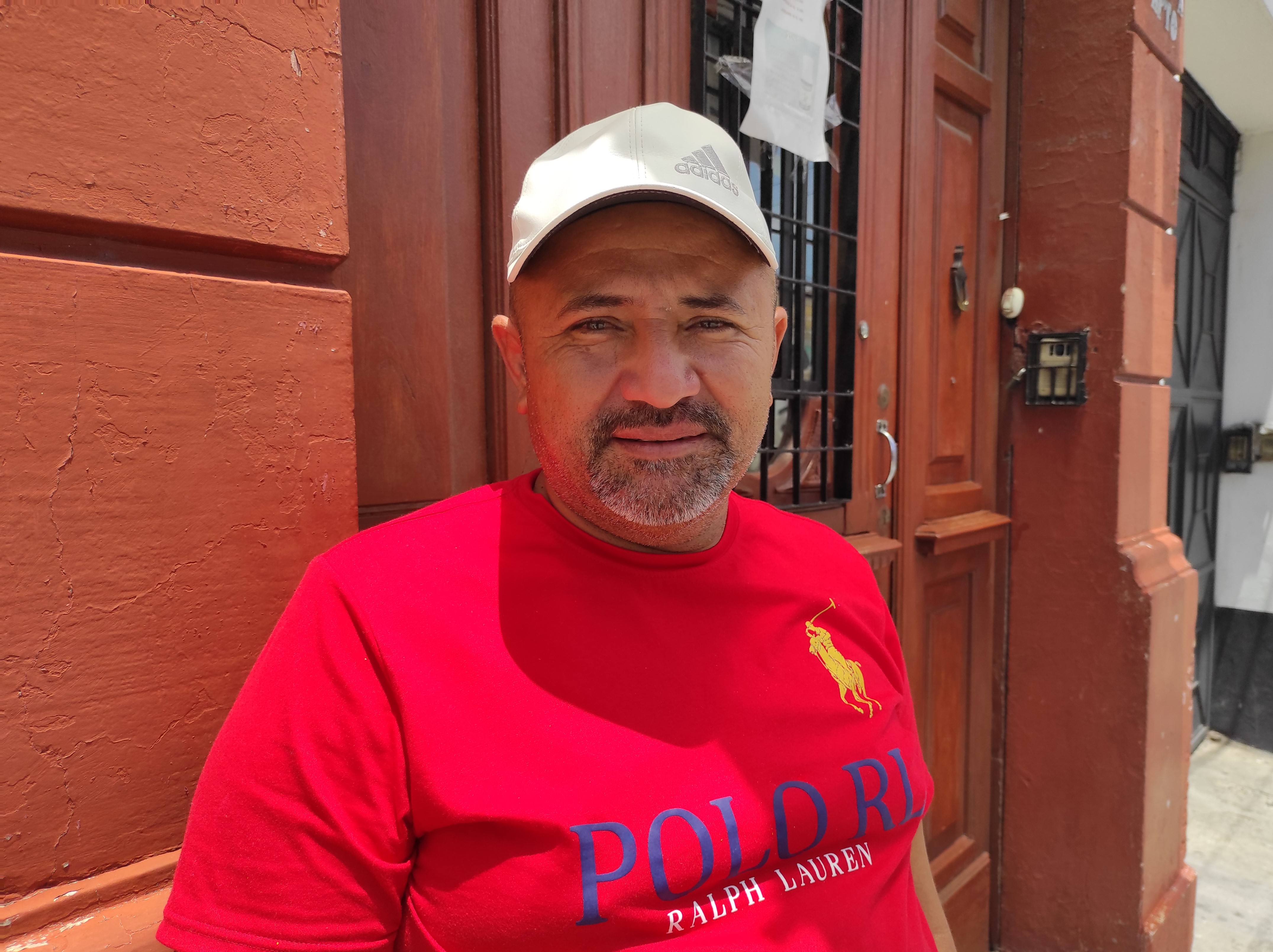 Alexander Sandoval, a farmworker, stands in front of a wall