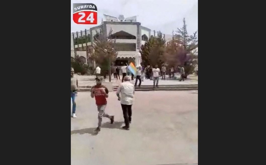 People run away during a protest in Sweida