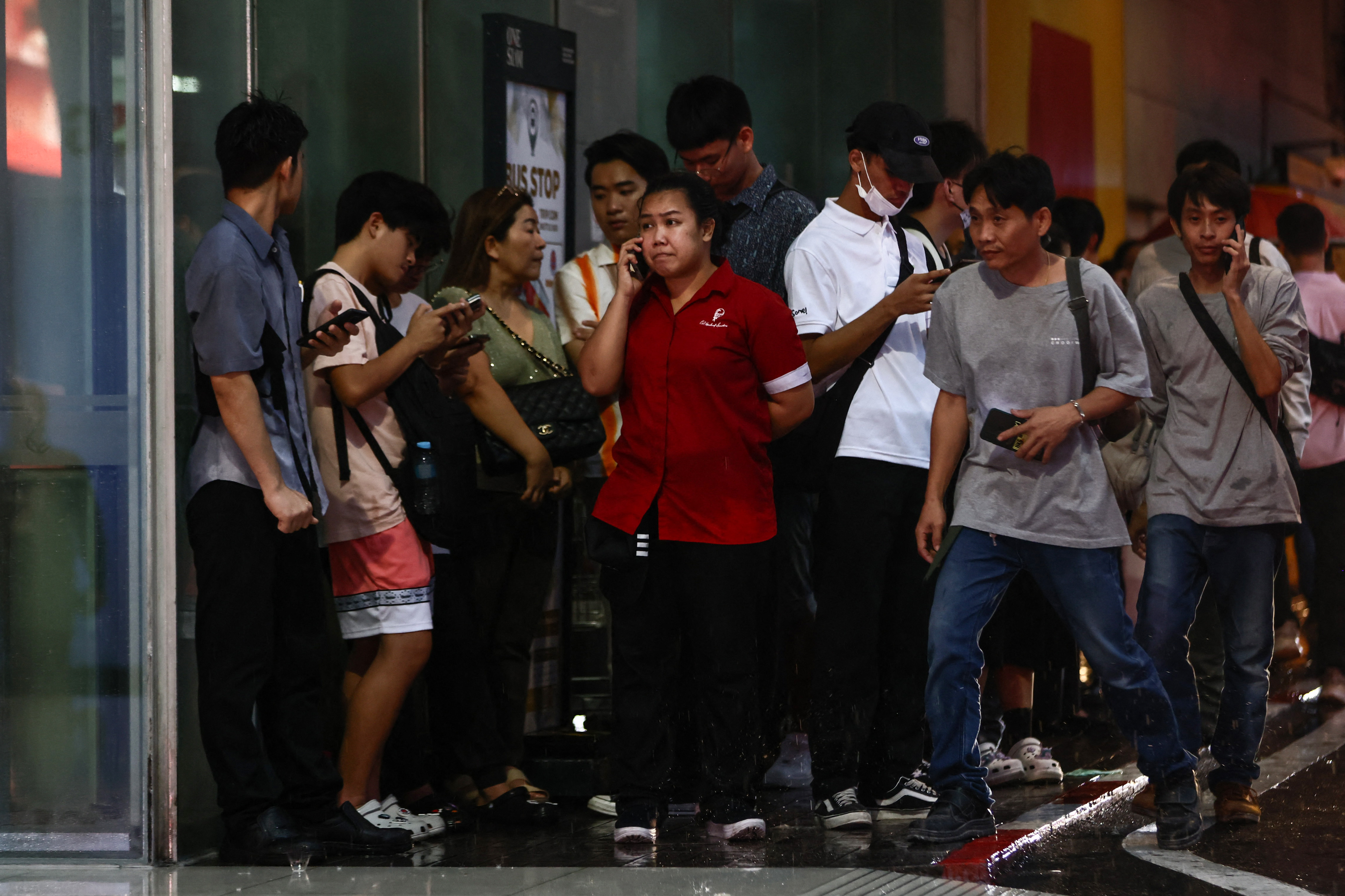 People stand outside Siam Paragon shopping centre in Bangkok