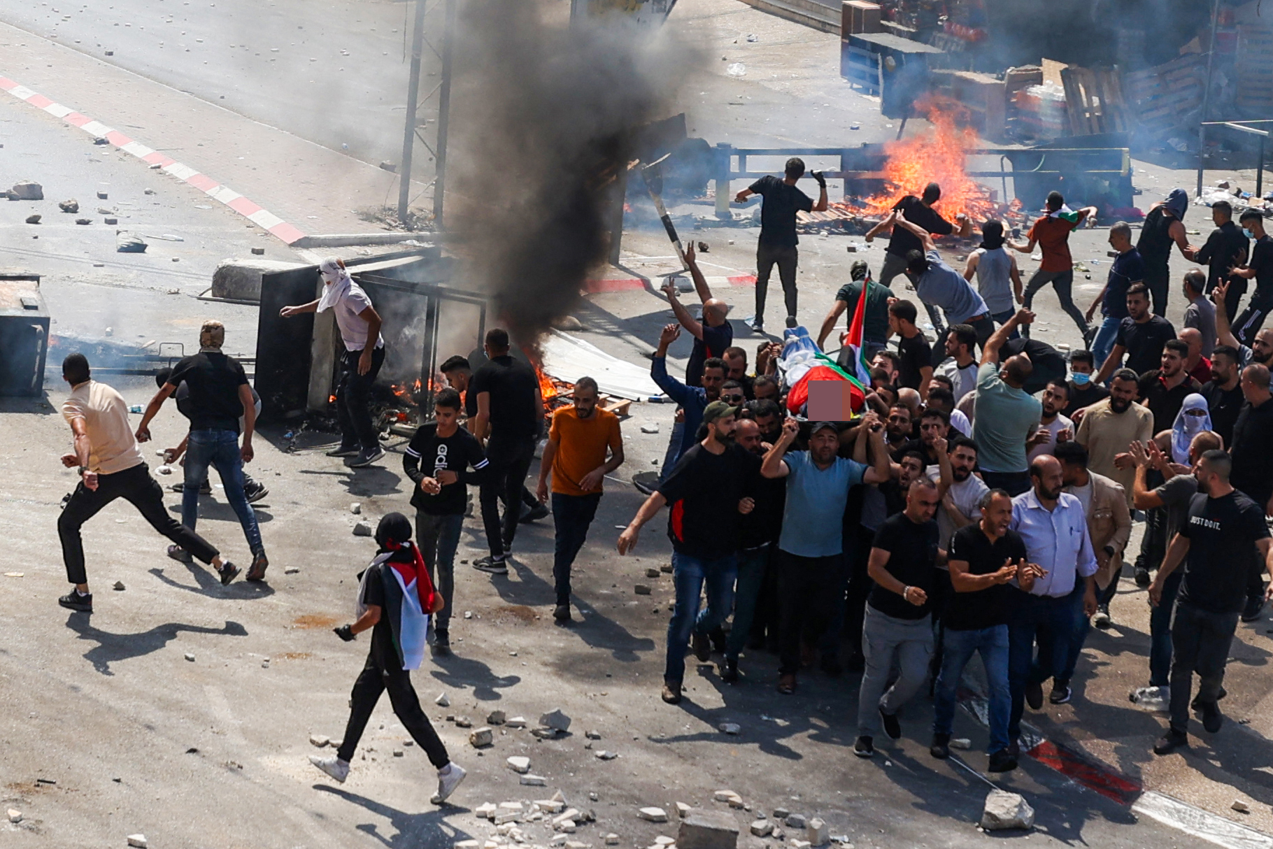 Palestinians clash with Israeli forces during the funeral of 19-year-old Labib Damidi, who was shot dead by settlers in the occupied West Bank town of Huwara
