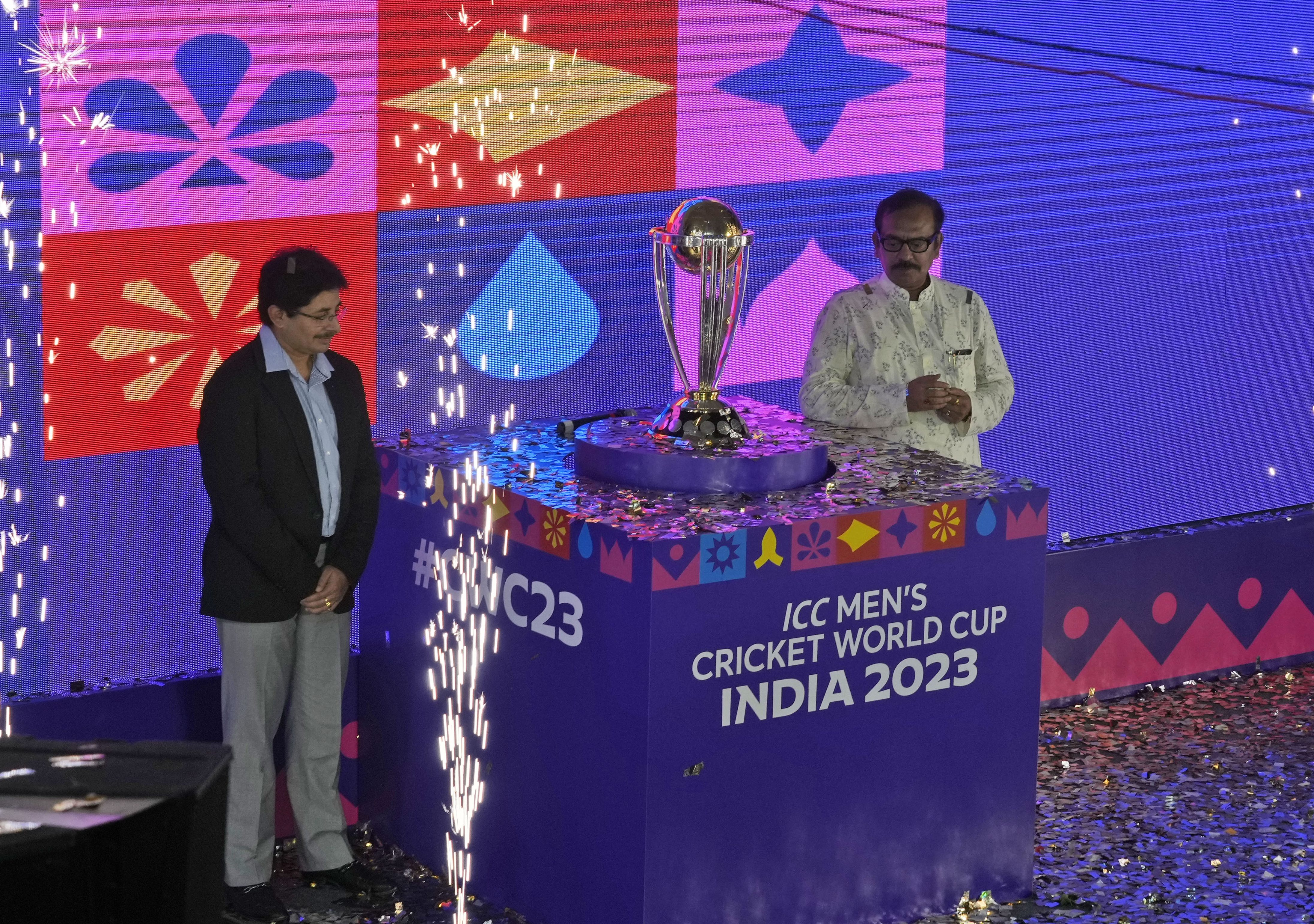 President of Cricket Association of Bengal (CAB) Snehasish Ganguly, left, and Arup Biswas, Minister of sports in Indian state of West Bengal pose with the ICC Cricket World Cup trophy