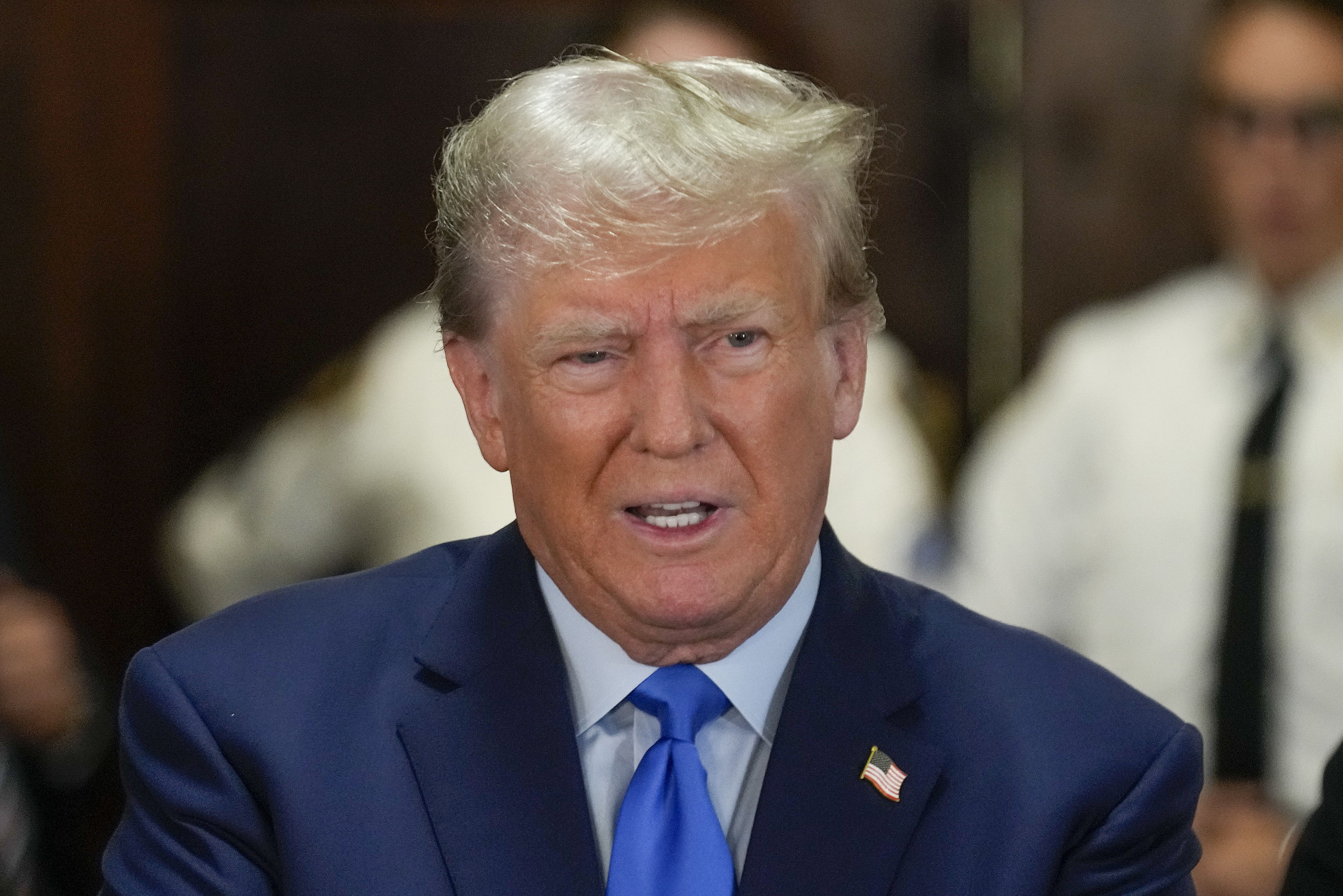Former President Donald Trump, center, speaks to the media upon arriving at New York Supreme Court
