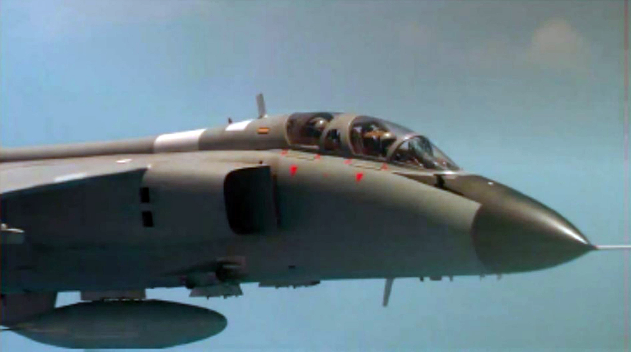 A Chinese fighter jet pictured from a US military aircraft. The cockpit crew are clearly visible.
