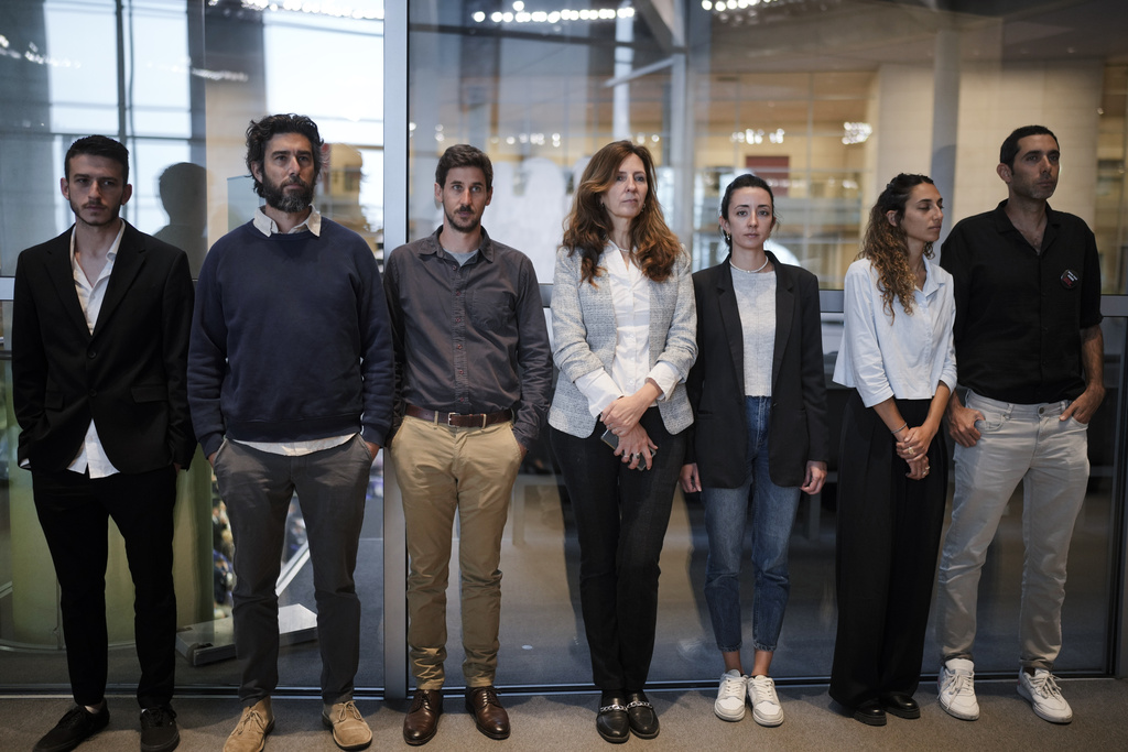 Relatives of those taken captive stand side by side at an event