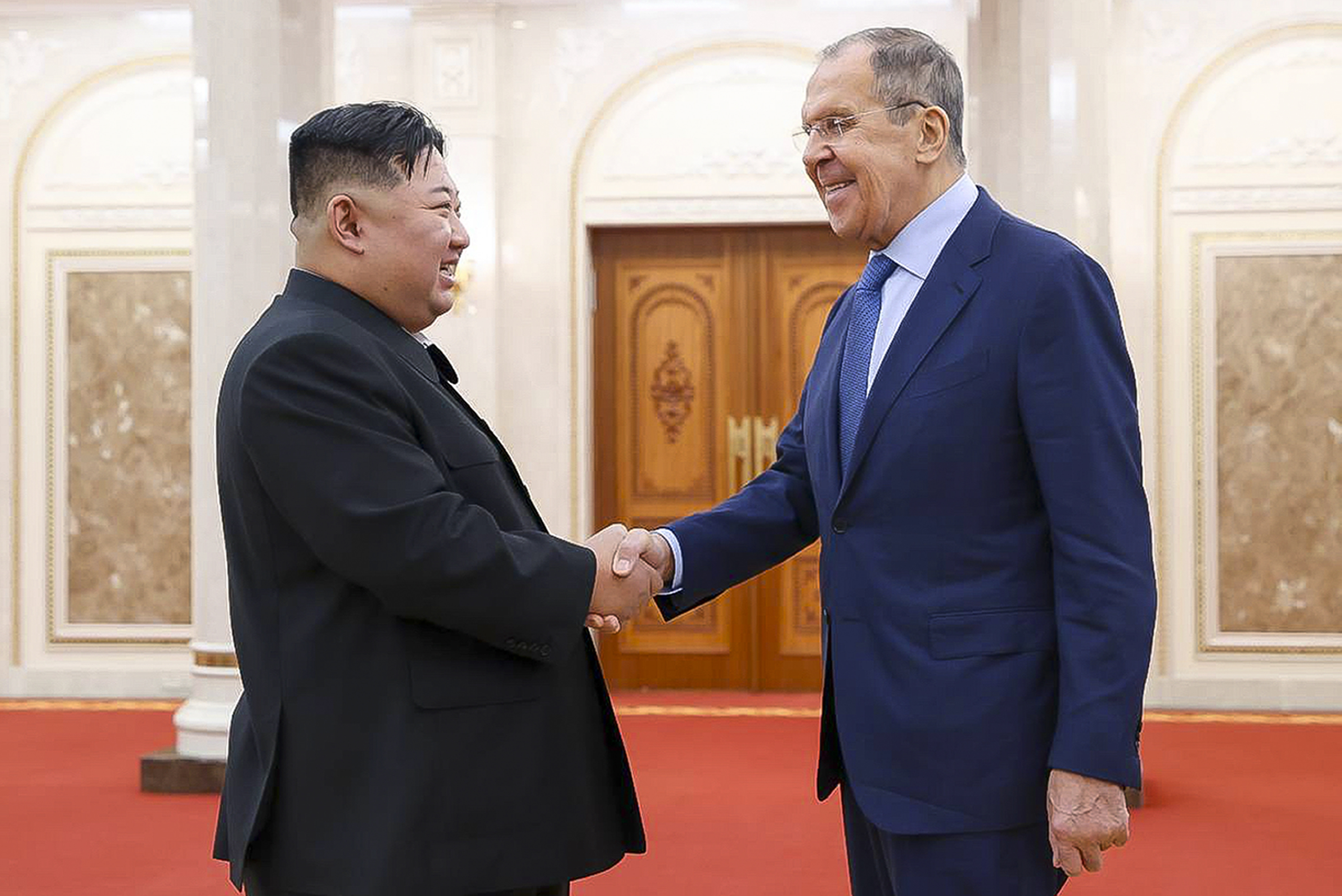 Kim Jong Un and Sergey Lavrov shake hands in Pyongyang, Both men are smiling