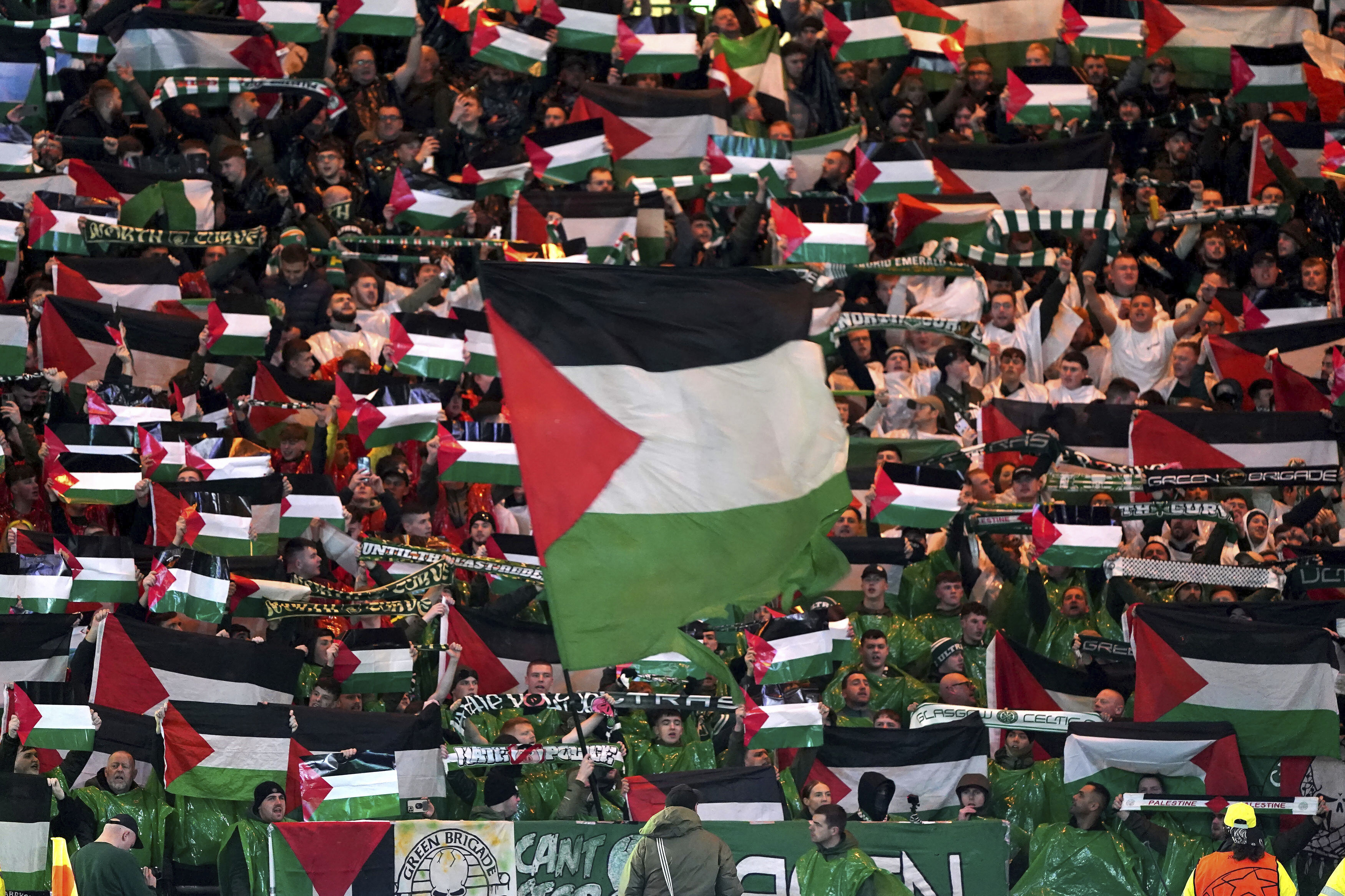 Celtic fans in the stands wave Palestinian flags