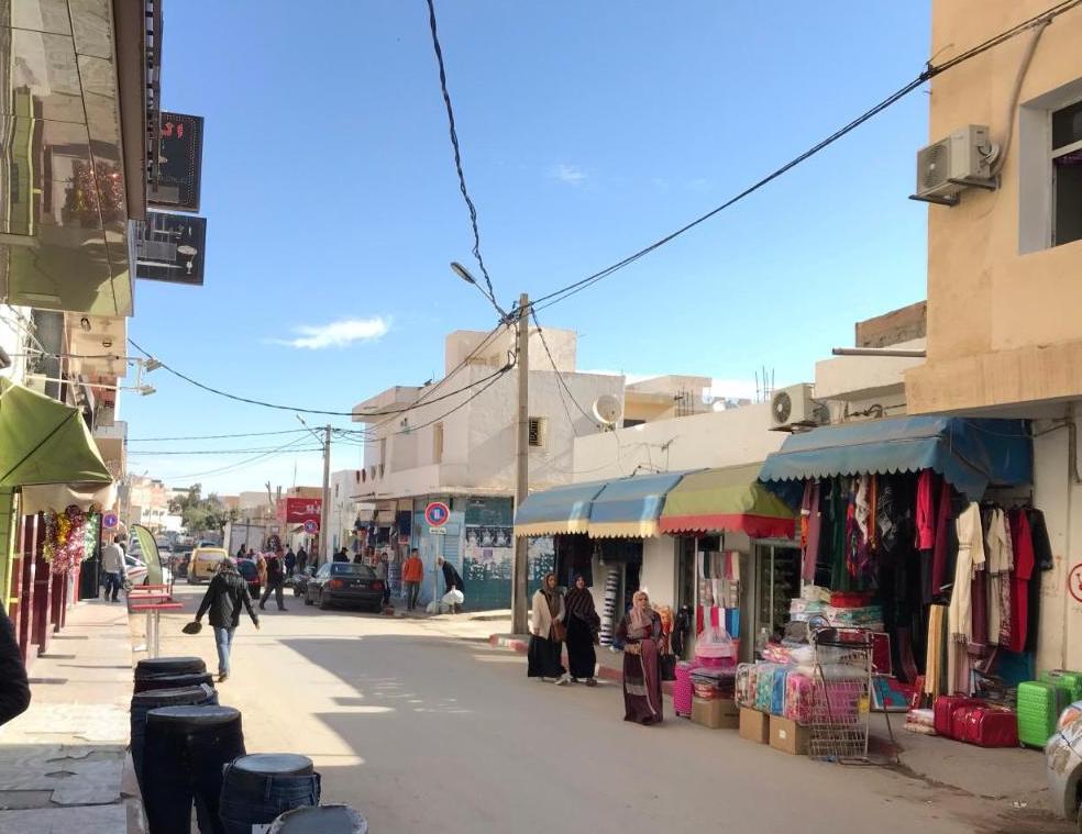 A photo of a street with shops on both sides.