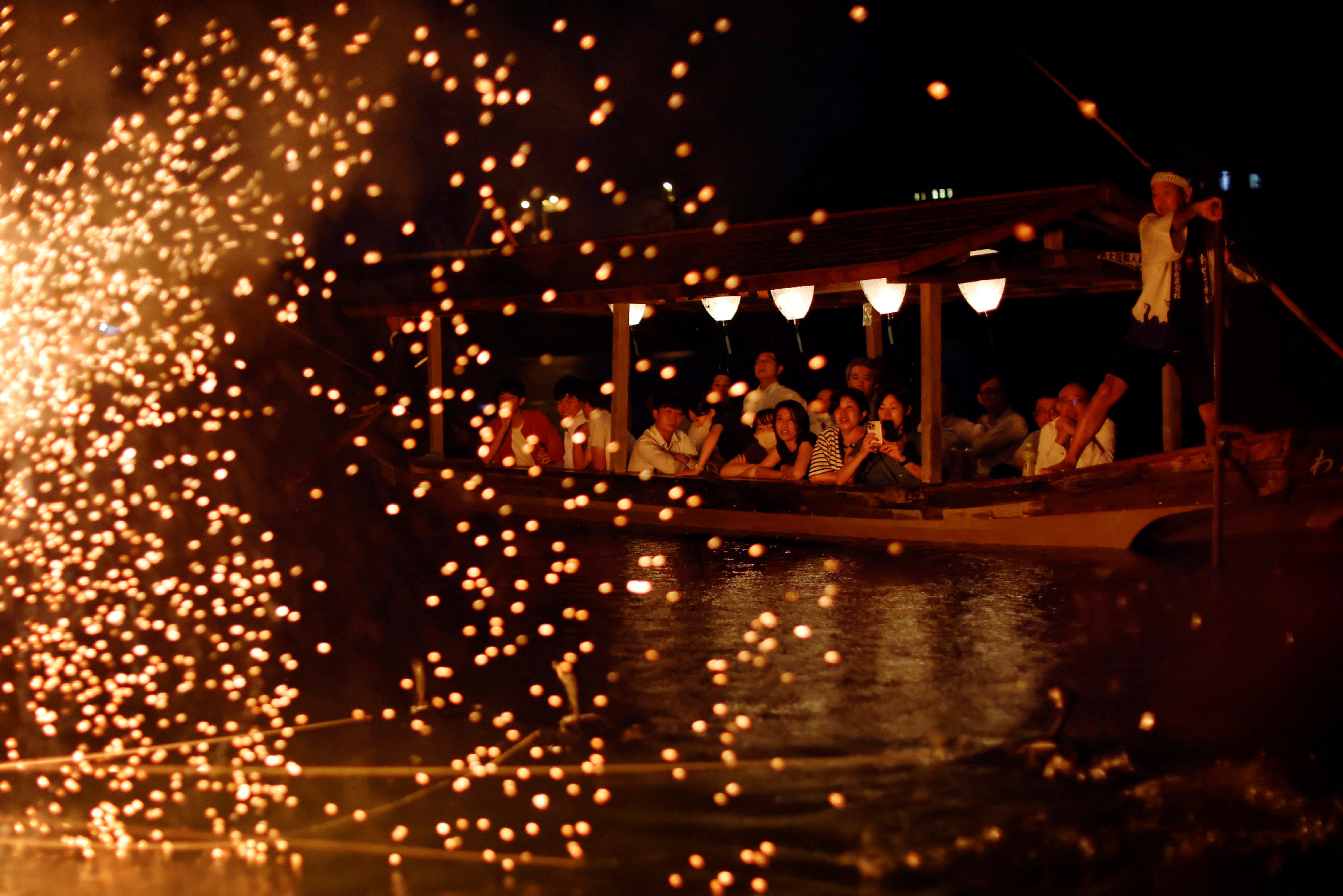 Spectators watch cormorant fishing master, known as usho, Youichiro Adachi (not pictured), 48, from a viewing boat on the Nagara River in Oze, Seki, Japan.