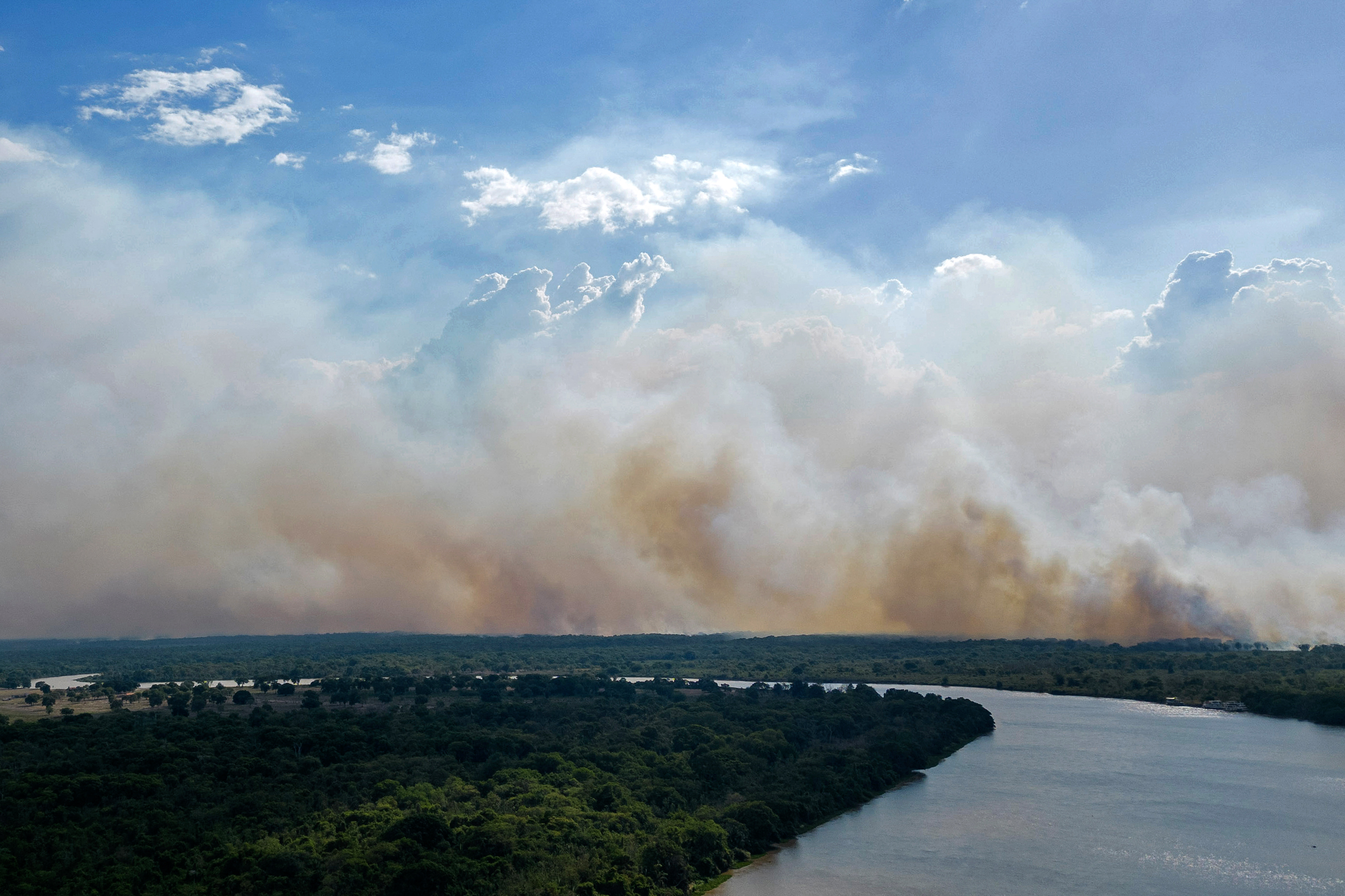 Aerial view showing smoke billowing from forest fires in the Pantanal wetland in Porto Jofre, Mato Grosso State, Brazil.