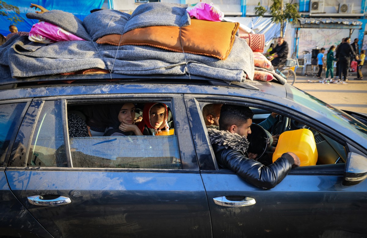 Palestinians who had taken refuge in temporary shelters return to their homes in eastern Khan Yunis in the southern Gaza Strip during the first hours of a four-day truce in the battles between Israel and Hamas militants