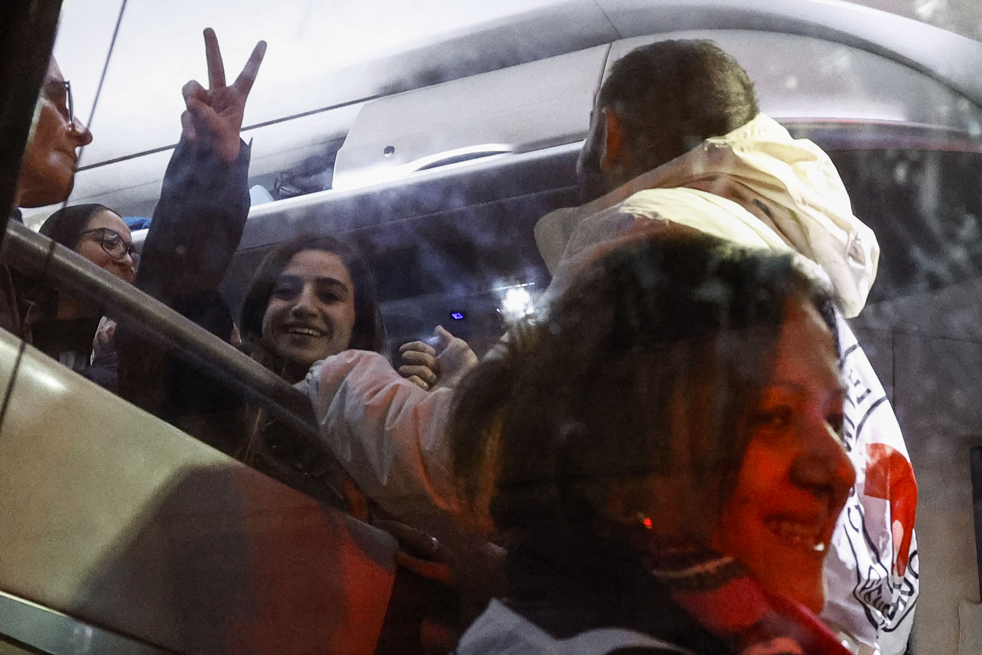 A newly released Palestinian detainee gestures from inside a Red Cross bus carrying Palestinian prisoners released from Israeli jails in exchange for hostages released by Hamas from the Gaza Strip, in Ramallah in the occupied West Bank on November 28
