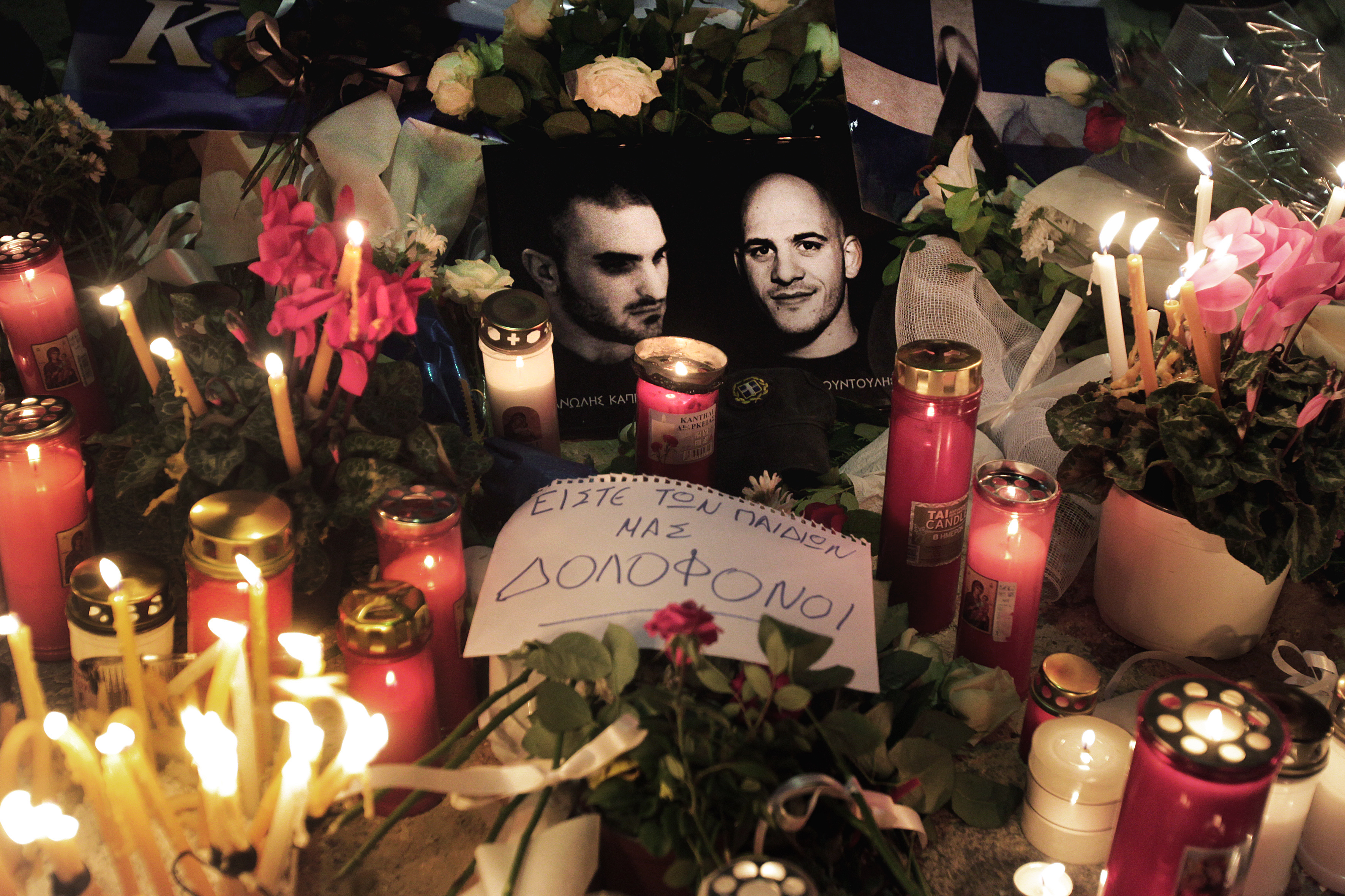 epa03934044 A note among flowers and candles reads 'You're your children's assasins', outside the local branch of ultra-right wing Golden Dawn party at the northern suburb of Neo Iraklio, at the point where two members of Golden Dawn where killed the previous night in Athens, Greece, 02 November 2013. Two young men were killed and one was seriously injured in a drive-by shooting in the Athens suburb of Neo Iraklio on 01 November evening, outside the local branch of the far-right party Golden Dawn (Chryssi Avgi). EPA/SIMELA PANTZARTZI