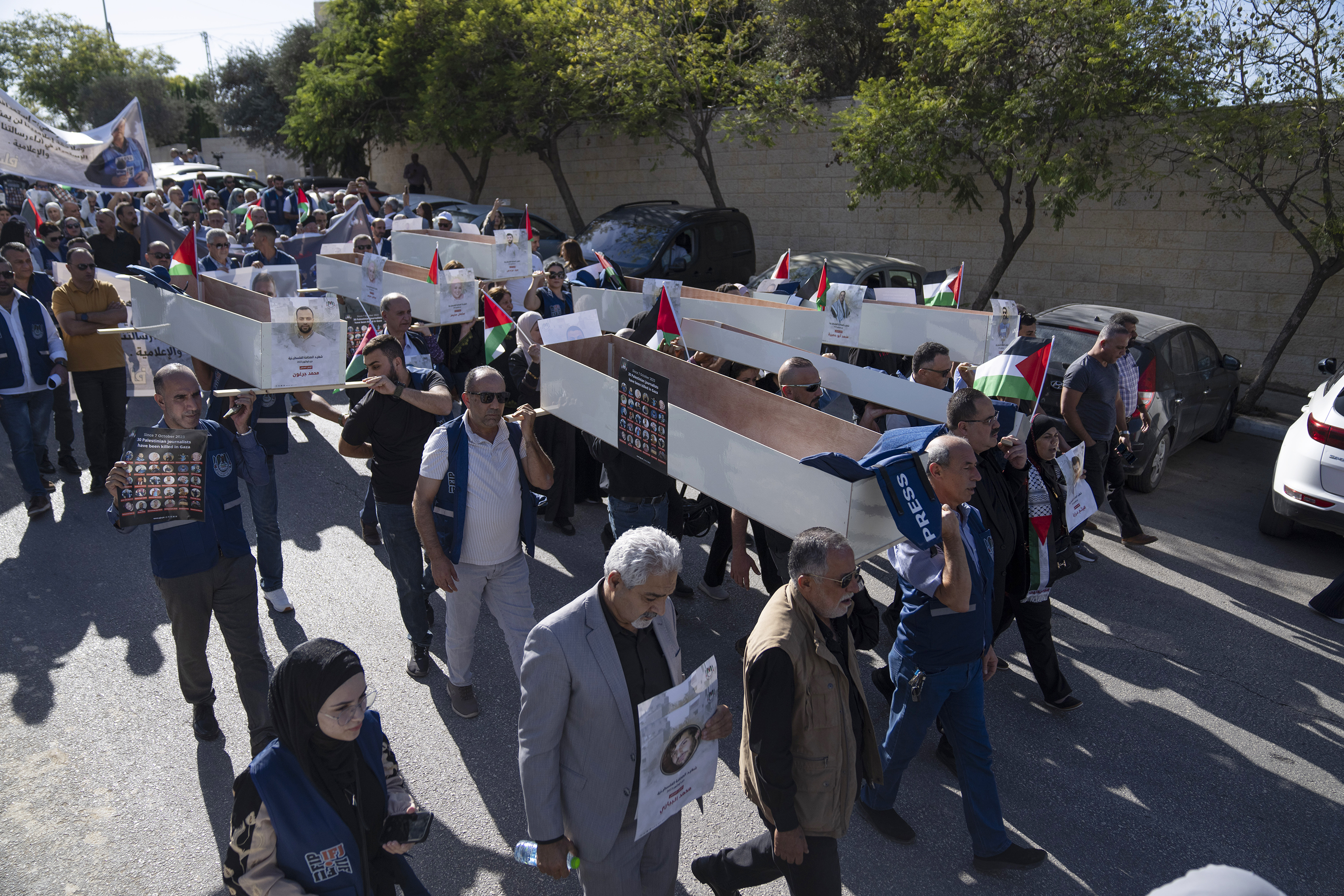 Palestinian journalists carry mock coffins of Palestinian journalists who were killed during the current war in Gaza during a symbolic funeral toward a United Nations office, in the West Bank city of Ramallah, Tuesday, Nov. 7, 2023. The Palestinian Journalist syndicate delivered a statement to U.N. office that states in part of it "as since the start of aggression against Gaza on October 7th, 30 Palestinian journalists have been killed." (AP Photo/Nasser Nasser)