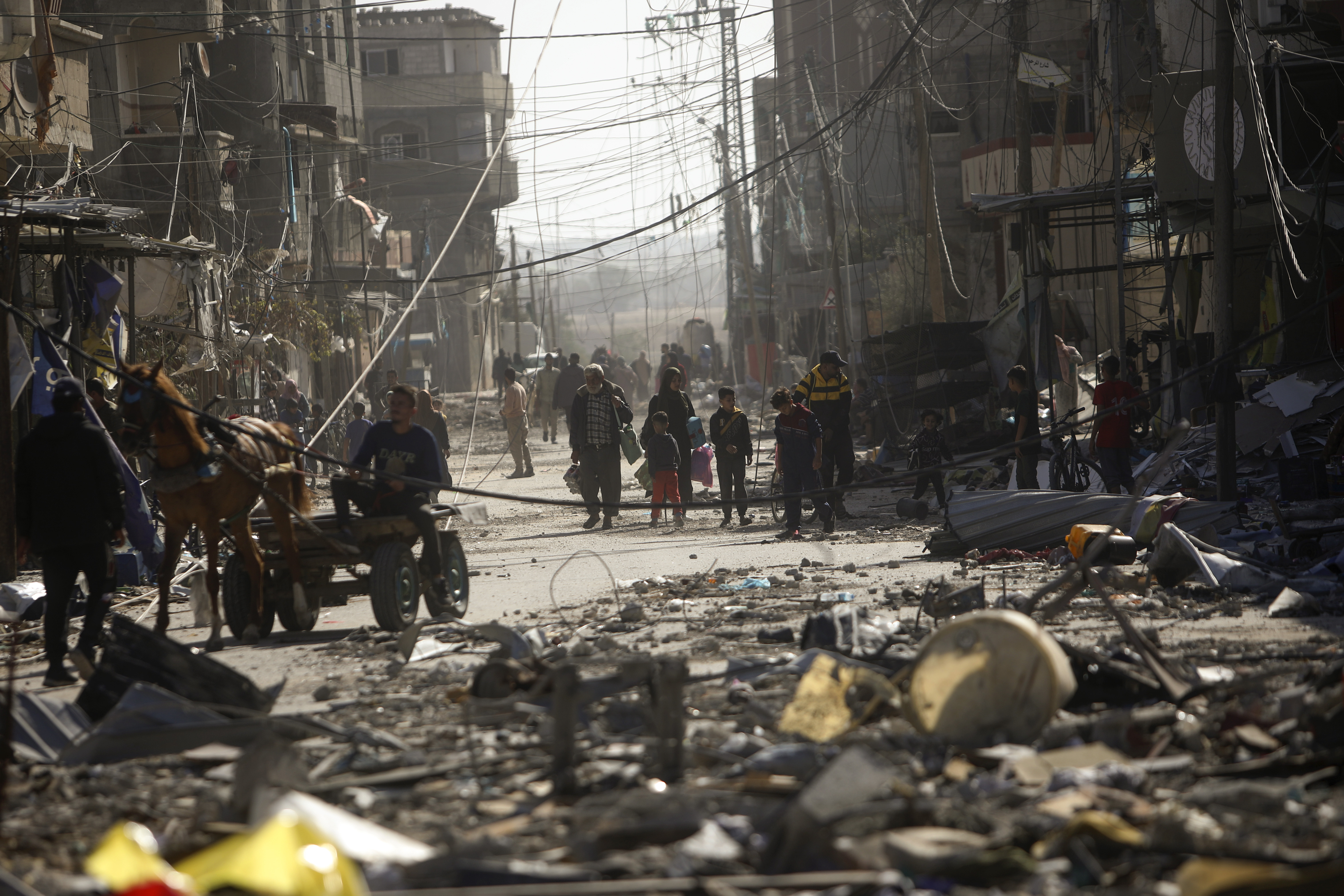 Palestinians inspect their destroyed houses in the town of Kazaa, eastern Khan Younis, southern Gaza Strip, Friday