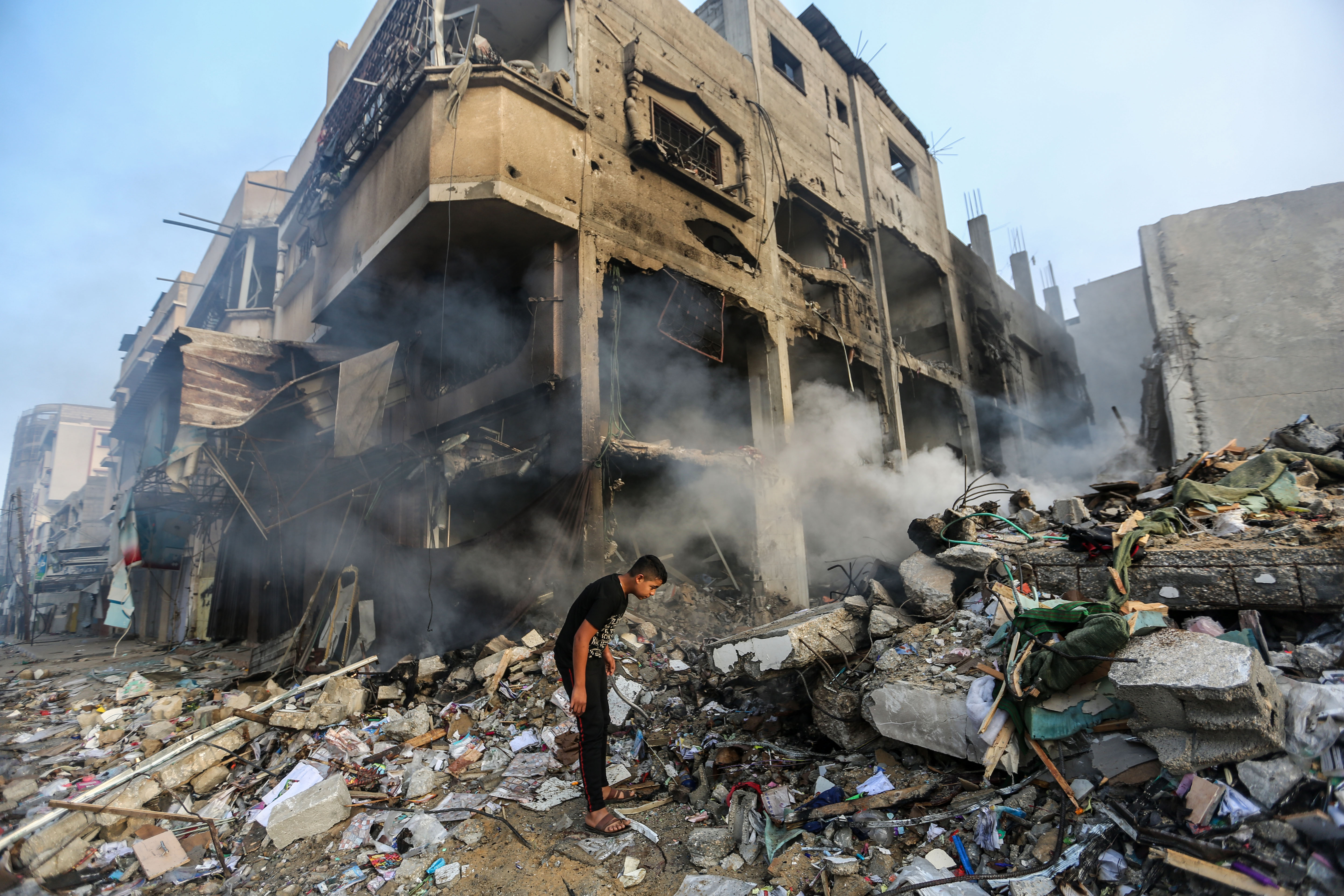 People search through buildings, destroyed during Israeli air raids in the southern Gaza Strip