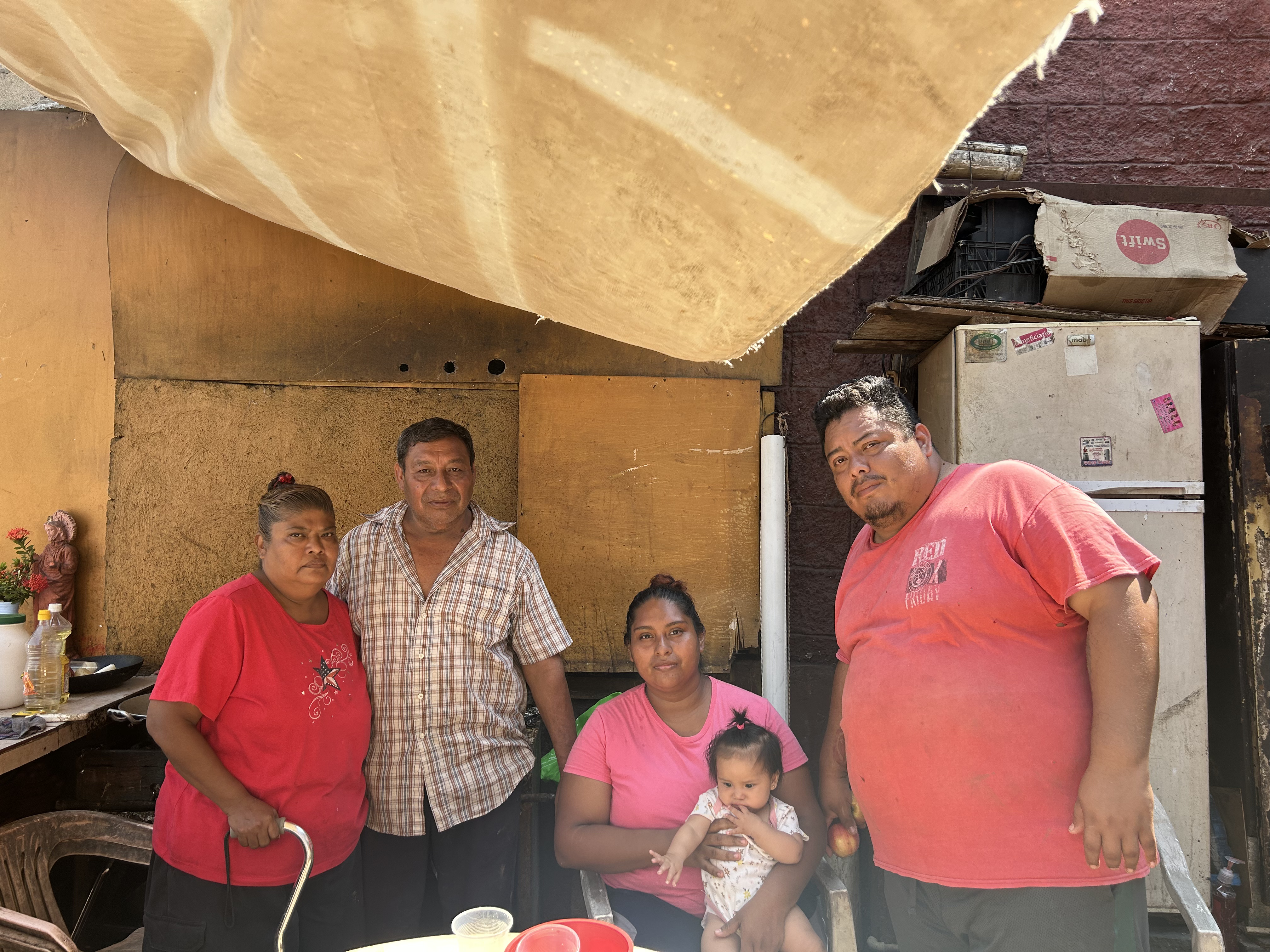 A family in Acapulco stands amid the wreckage left by Hurricane Otis.