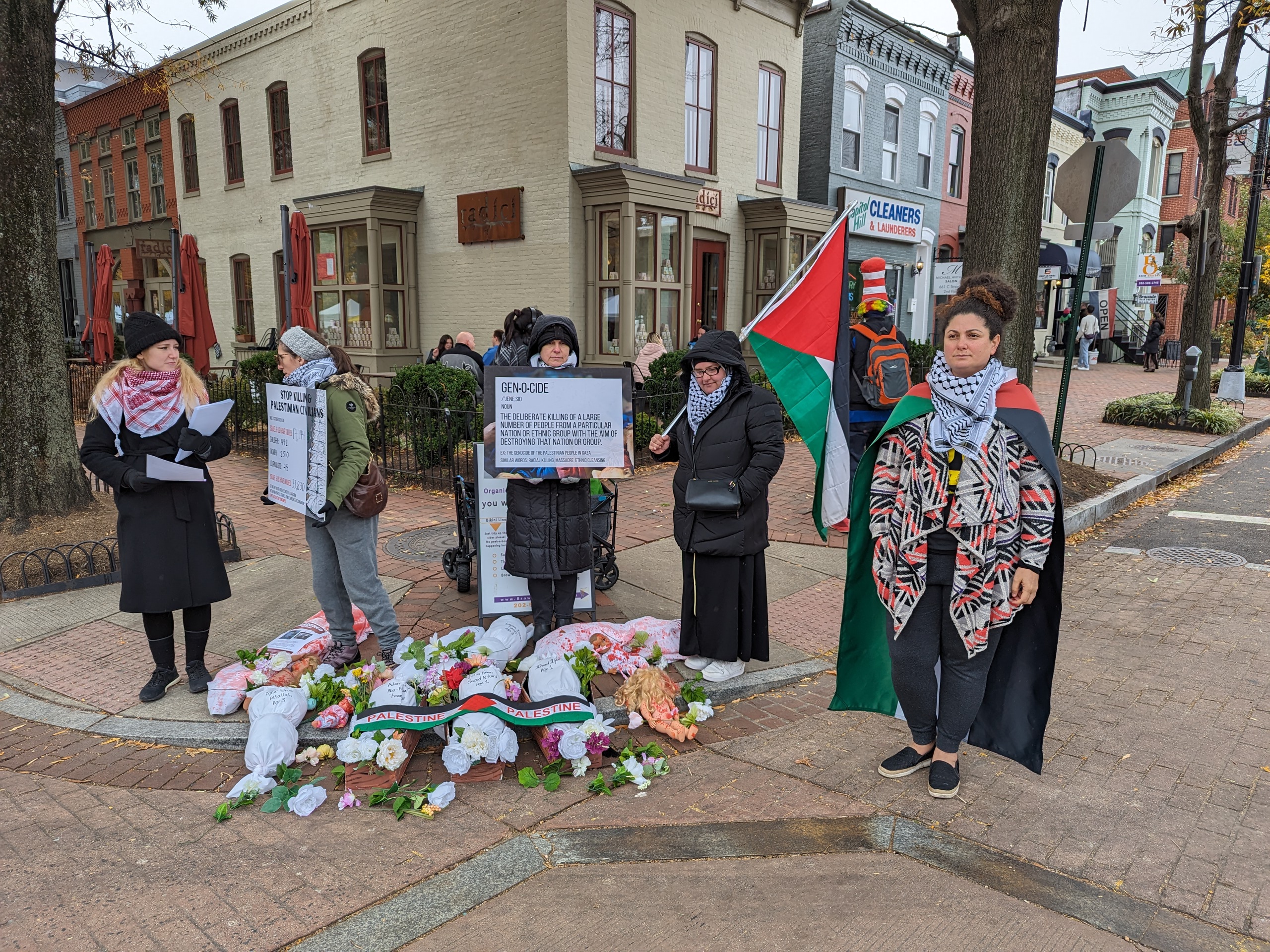 Activists stand on street corner by display depicting Palestinian children killed by Israeli attacks on Gaza