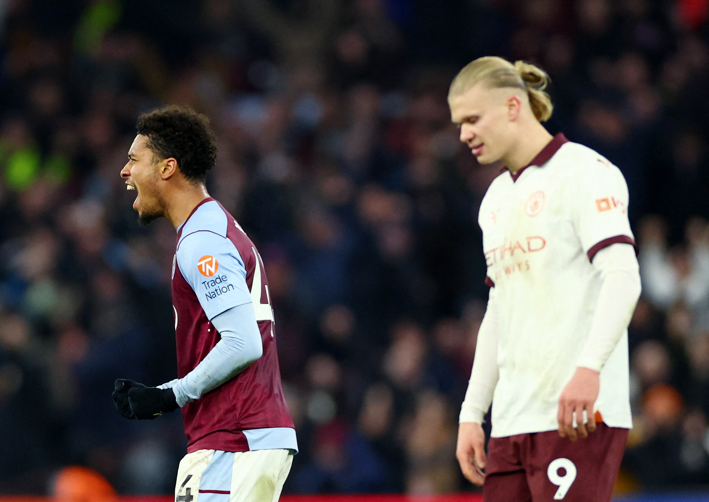 Aston Villa's Boubacar Kamara celebrates as Manchester City's Erling Haaland looks dejected after City's loss